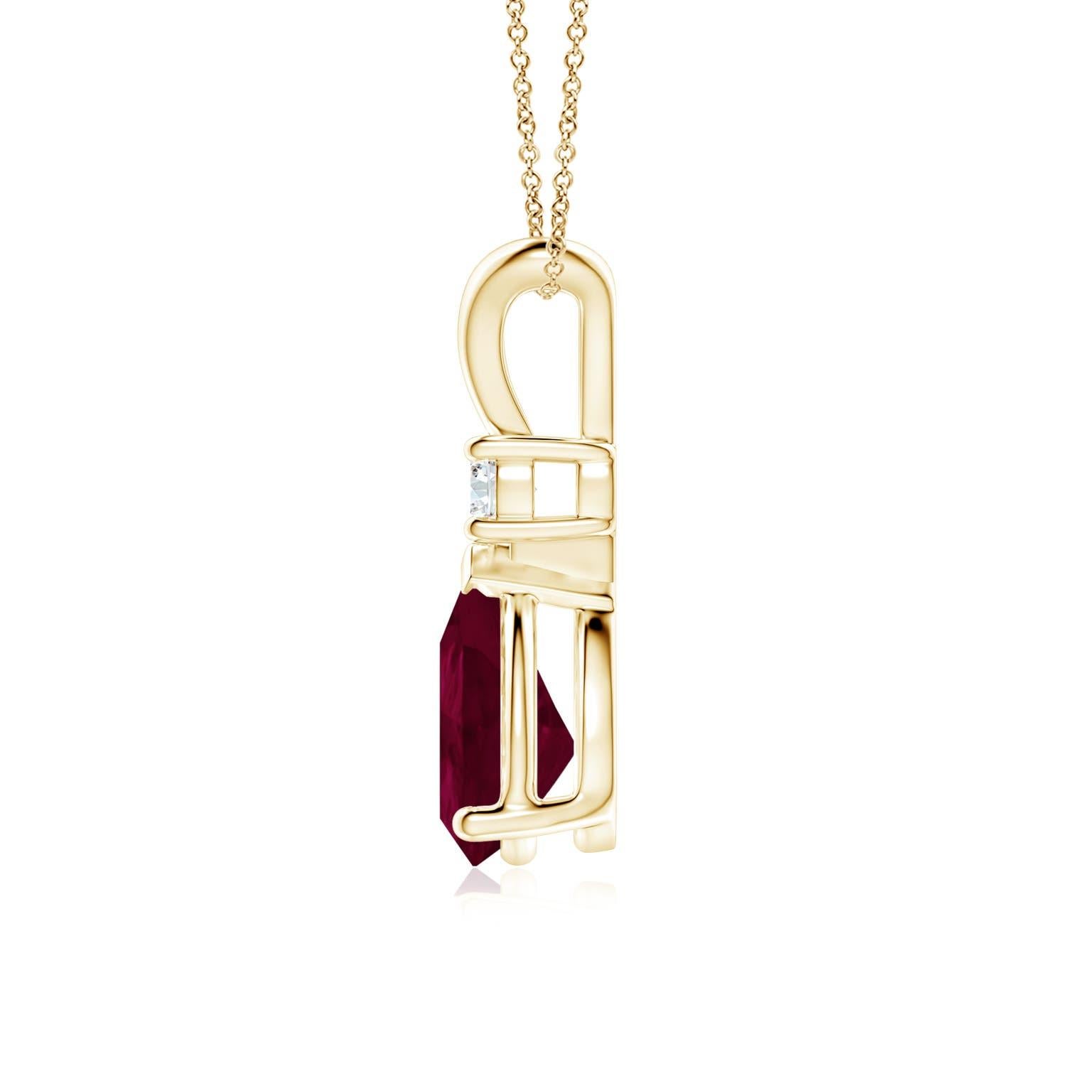 Ce pendentif solitaire classique est orné d'un rubis en forme de poire serti dans une monture à griffes. Un diamant rond brillant surmonte la pierre précieuse de couleur rouge pourpre. Simple mais séduisant, ce pendentif en or jaune 18k orné d'un