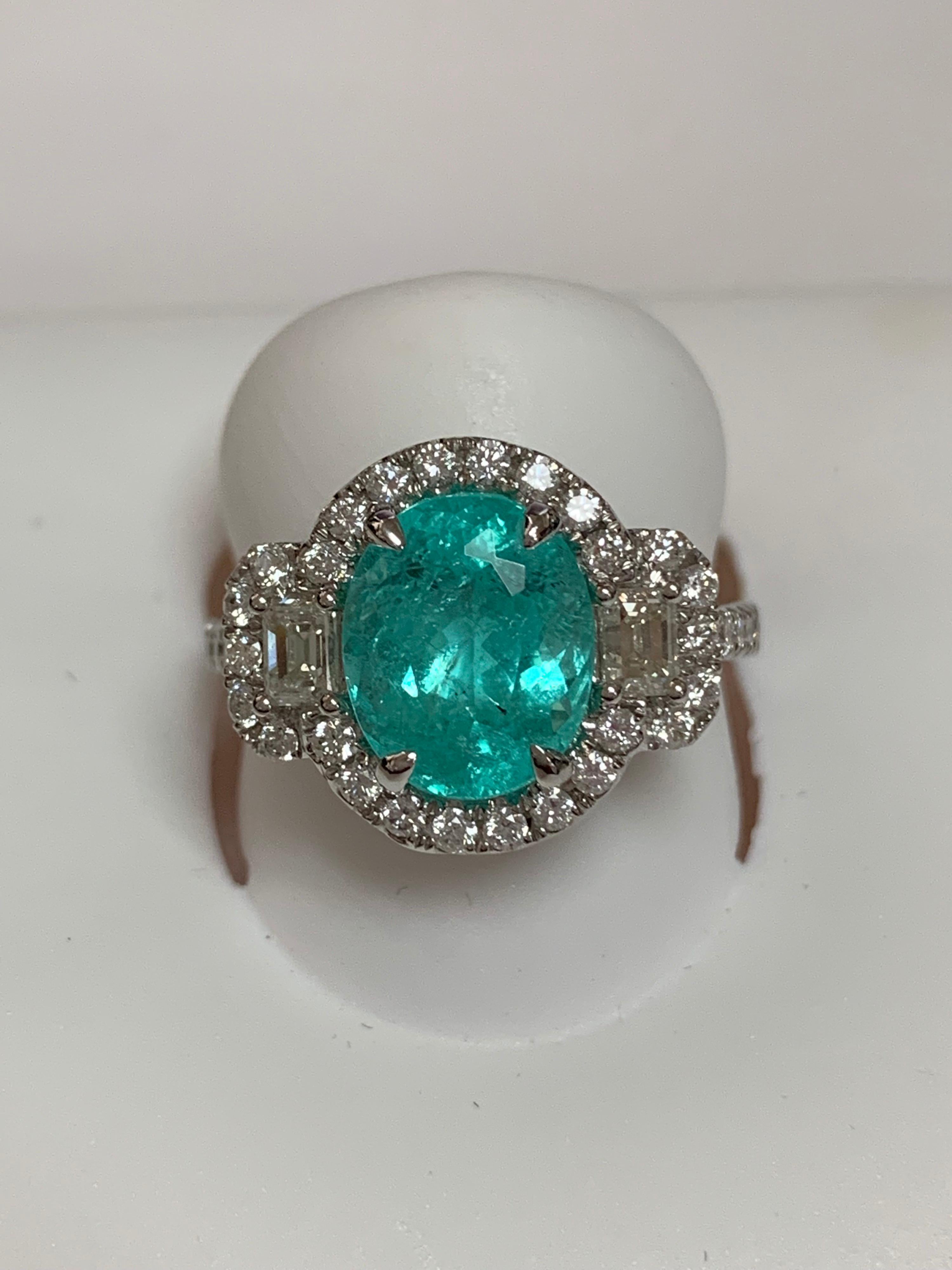 Natural copper bearing Tourmaline also known as Paraiba Tourmalineis 2.95 Carat  with additional 0.86 Carat White diamonds set in 18 Karat white gold is one of a kind handcrafted Ring. The ring is size 7 but can be resized if needed.