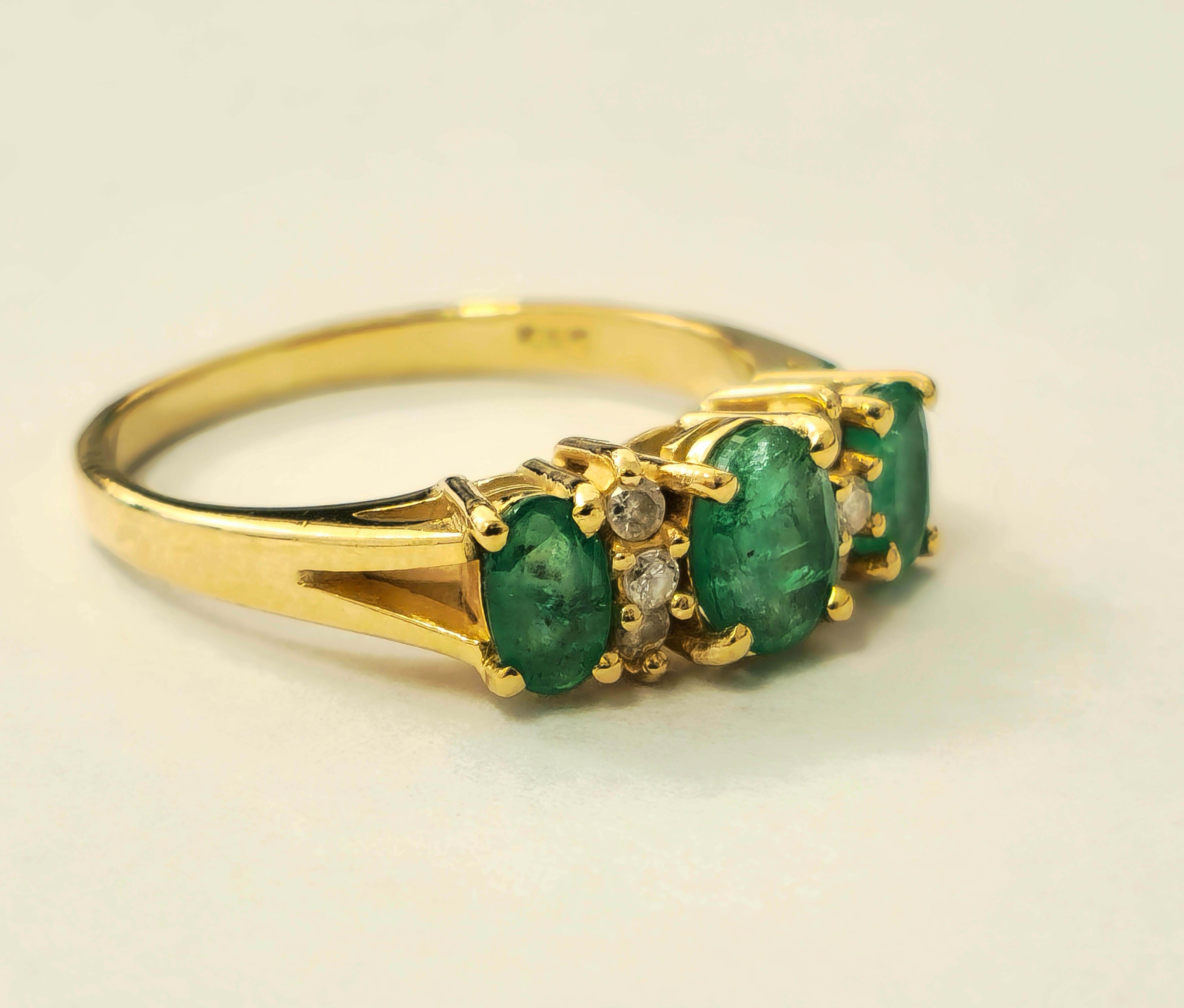 Dieser aus 14-karätigem Gelbgold gefertigte Vintage-Ring besticht durch einen 1-karätigen Smaragd im Ovalschliff, der von insgesamt 0,25 Karat natürlichen Diamanten aus Erdminen mit den Reinheitsgraden SI1-2 und der Farbe G flankiert wird. Mit einem