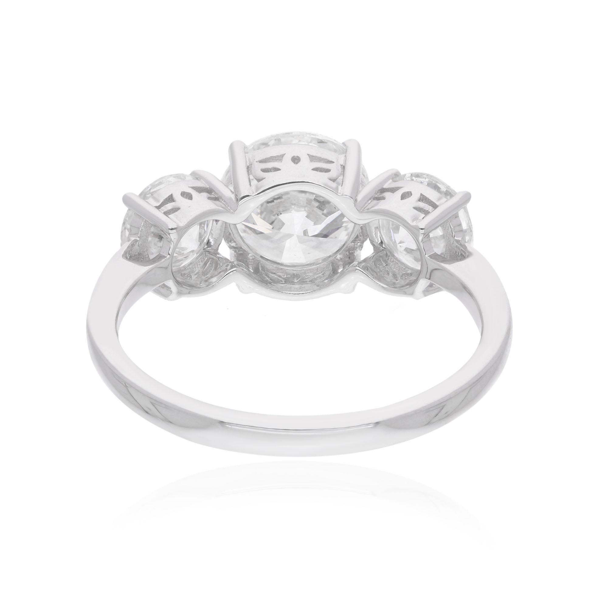 The centerpiece of this ring is a stunning round diamond, flanked by two smaller round diamonds on either side, creating a captivating display of brilliance and sparkle. Each diamond is meticulously selected for its exceptional quality and clarity,