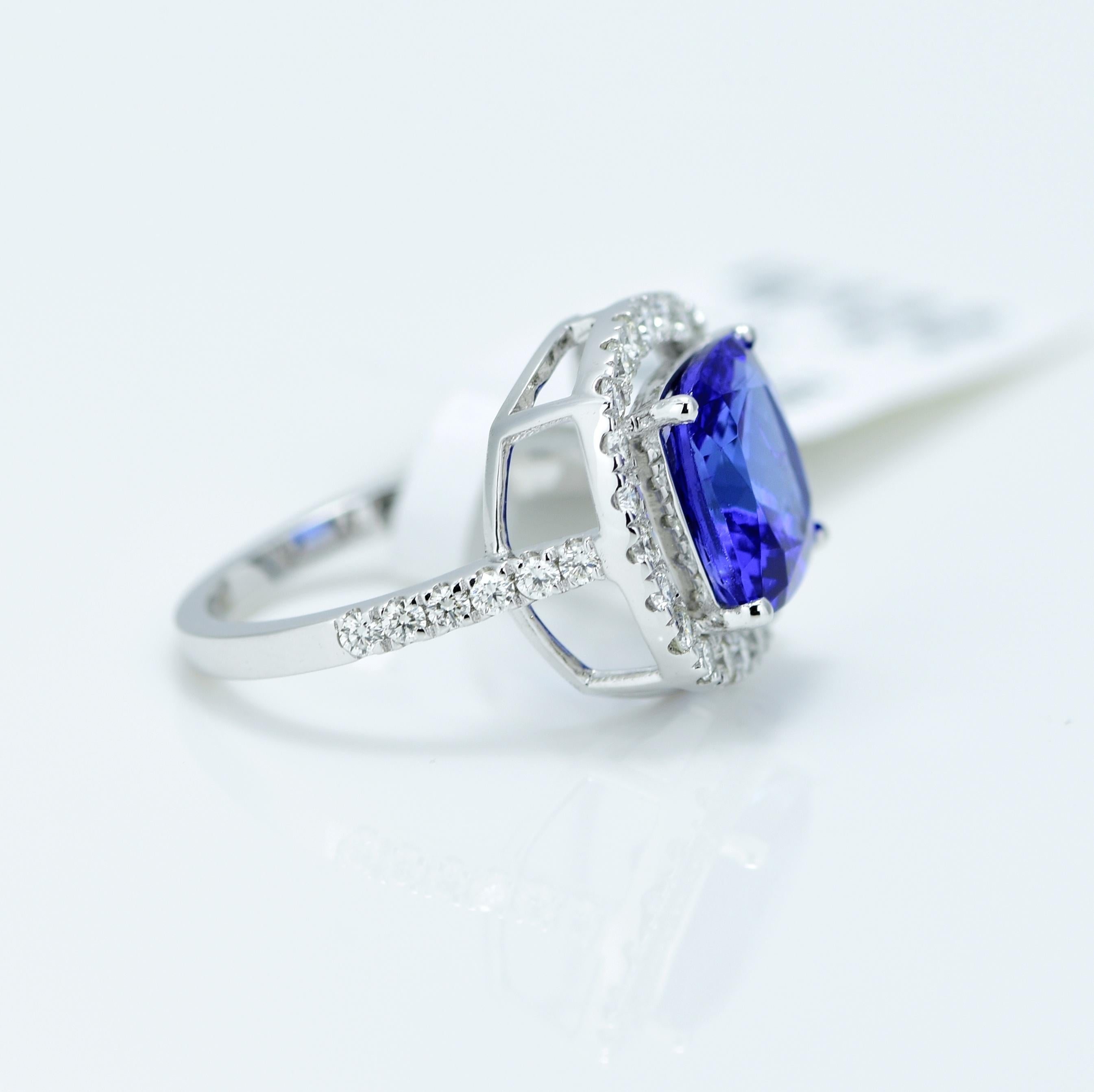 Stunning Violetish Blue Tanzanite and Diamond halo ring.

Centre Stone - Natural Tanzanite, 
Centre Stone Weight - 3.41 Carat, 
Centre Stone Shape & Cut - Cushion Step Cut
 
Total Number of Diamonds - 34, 
Diamonds Carat Weight - 0.56 carat
Diamond