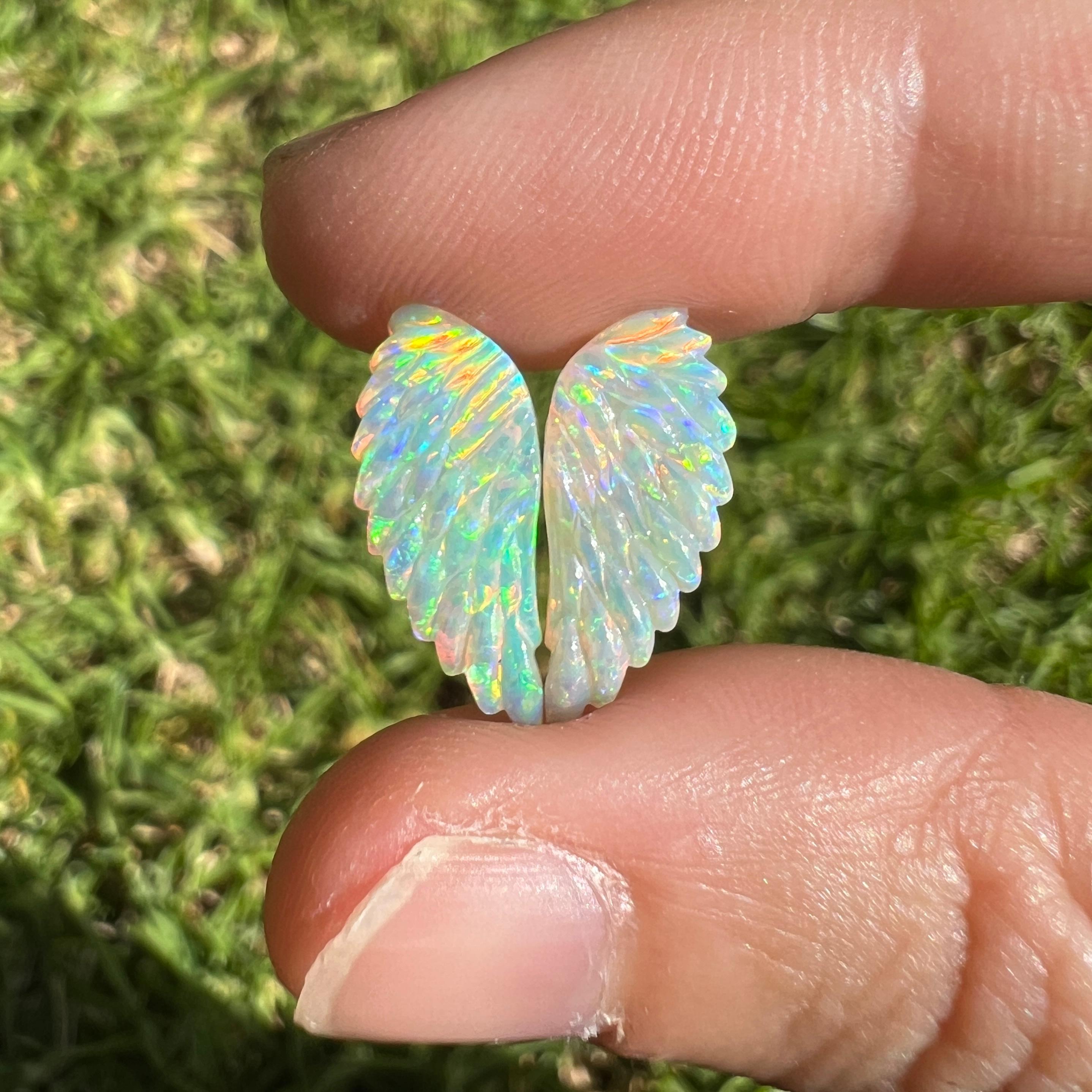 This 3.66 Ct natural Australian gem crystal opal, carved into a pair of angel wings, is a truly exceptional addition to any collection, mined by Sue Cooper herself. Its rarity, coupled with the amazing winged carving, captivates connoisseurs with