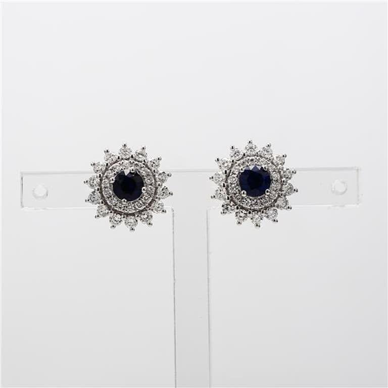 RareGemWorld's classic sapphire earrings. Mounted in a beautiful 14K White Gold setting with natural round cut blue sapphires. The sapphires are surrounded by natural round white diamond melee in a beautiful single halo as well as a flower pedal
