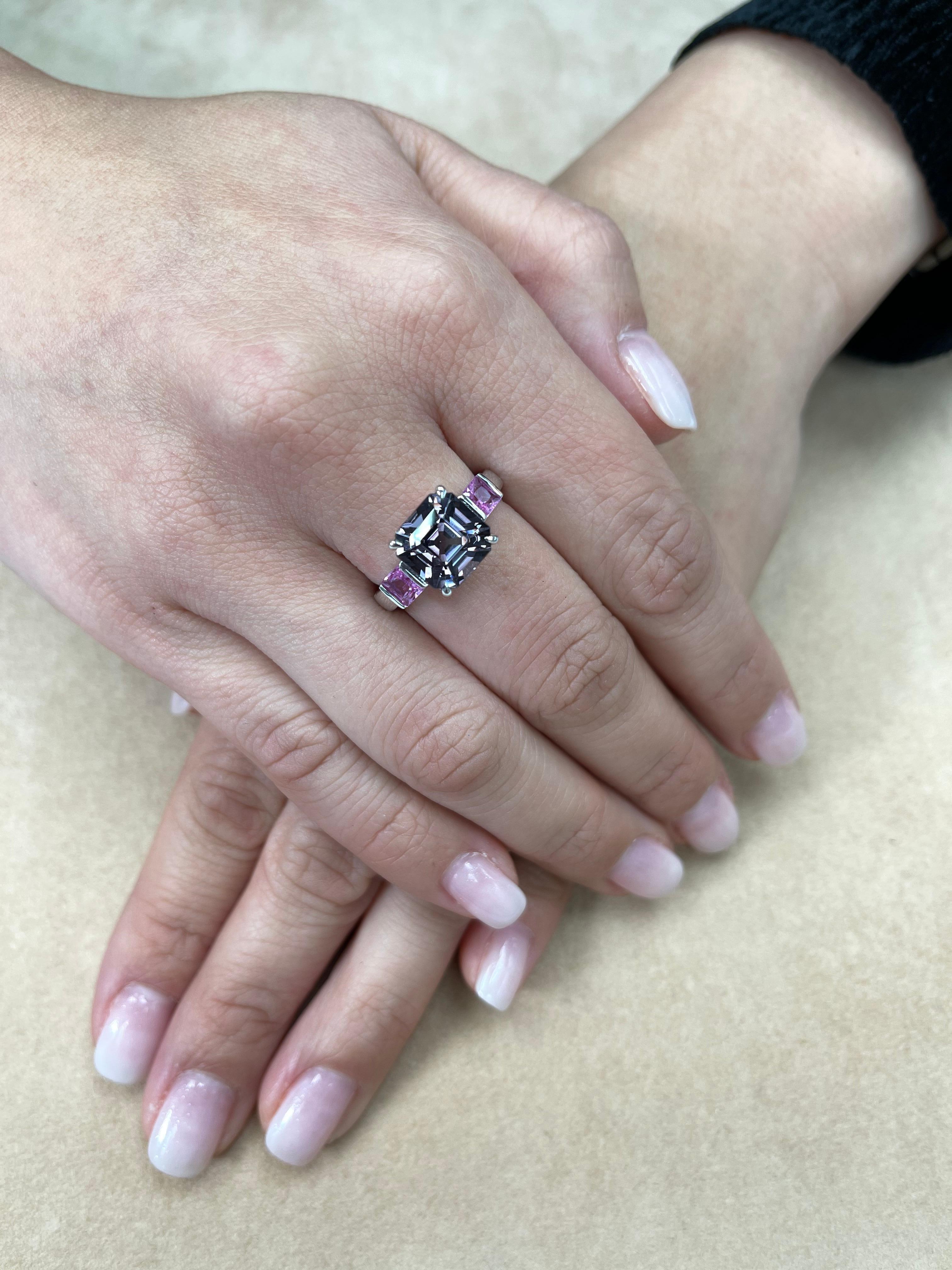 A unique color combination. Here is a superb Asscher cut Spinel and hot pink sapphire 3 stone cocktail ring. The ring is set in 18k white gold. The center Asscher cut purple spinel is 4.28 cts. The Natural Spinel is well cut. The color is crispy and