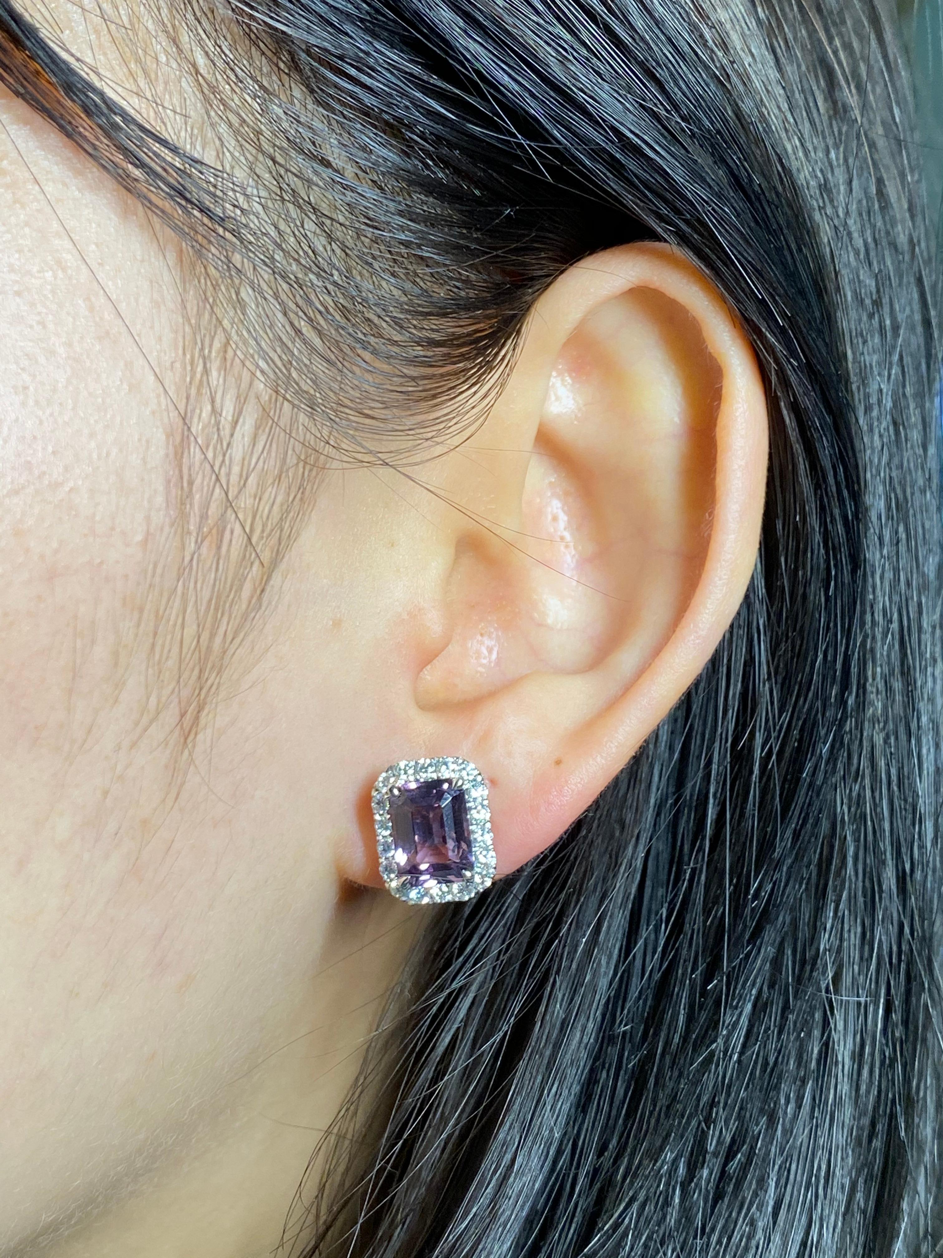 Here is a pair of purple step cut spinel and diamond halo earrings. The earrings are set in 18k white gold and diamonds. The 0.67 Cts of full cut diamonds are of high quality. Two natural spinels about 2.36 cts each totaling 4.73 cts make up these