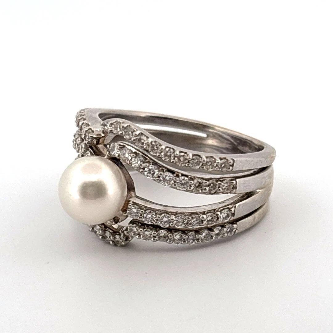 Elegant and timeless, this estate ring is crafted in solid 14K white gold and showcases a luminous 7.25mm cultured Akoya pearl, framed by approximately 0.48 carats of natural round brilliant diamonds. The wide, stylish setting makes a statement