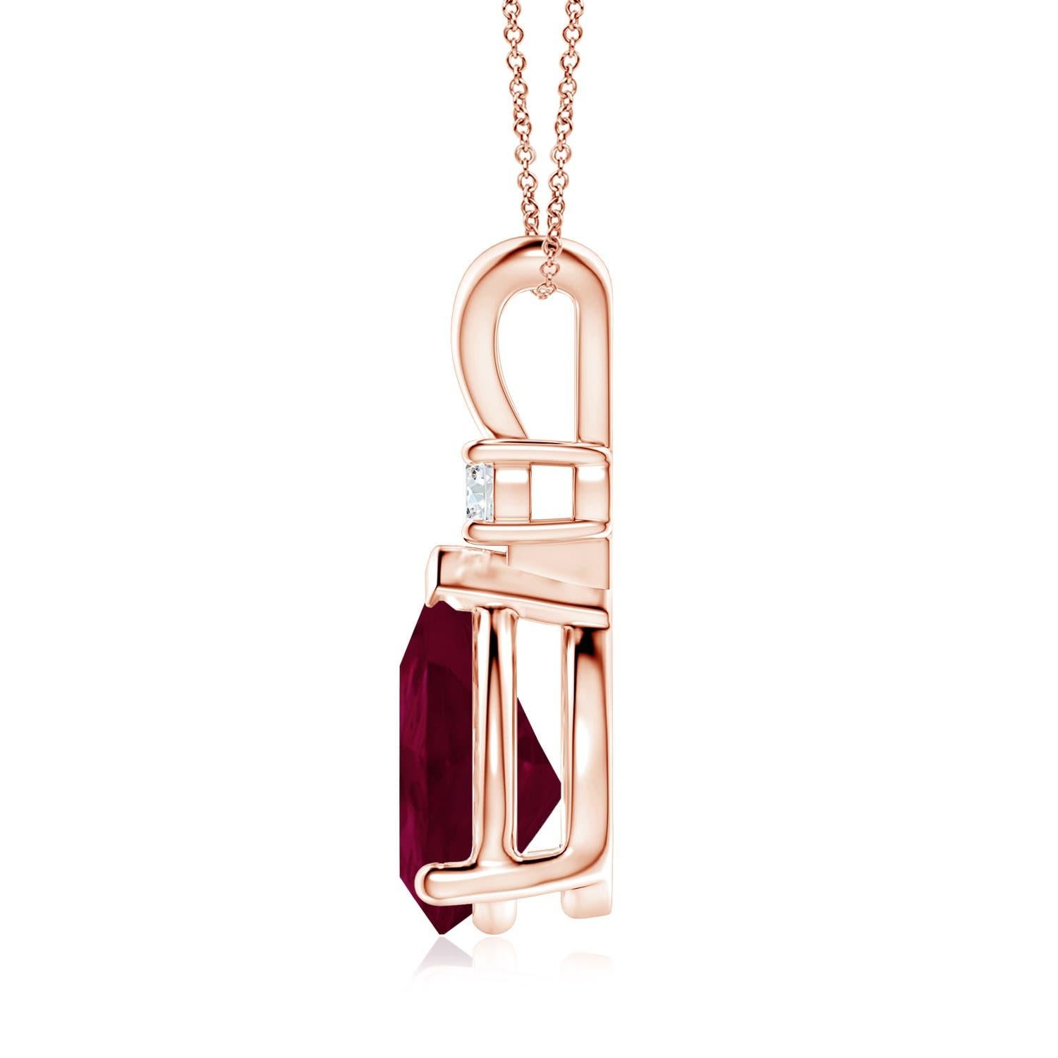 Ce pendentif solitaire classique est orné d'un rubis en forme de poire serti dans une monture à griffes. Un diamant rond brillant surmonte la pierre précieuse de couleur rouge pourpre. Simple mais séduisant, ce pendentif en or rose 18k orné d'un