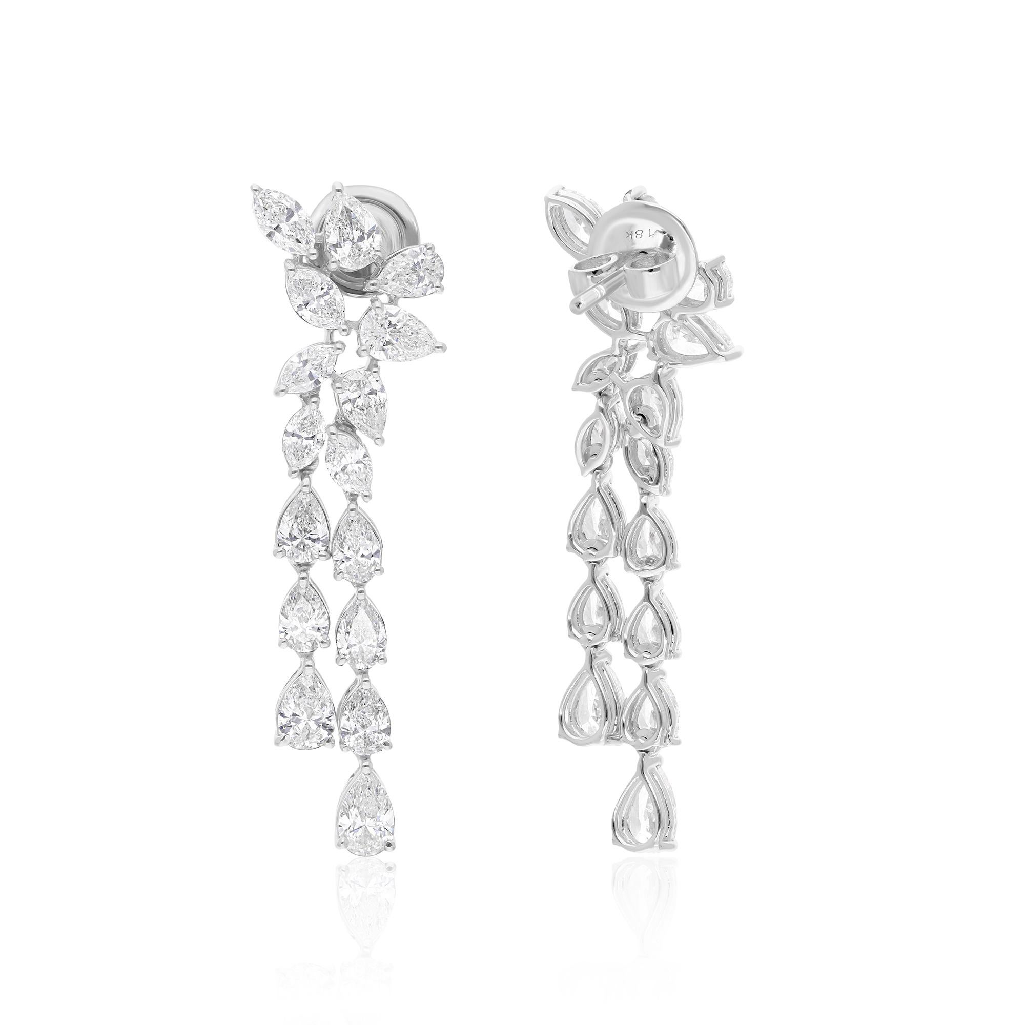 The focal point of these earrings is the pear-cut diamond, gracefully suspended from the earlobe, showcasing its classic teardrop shape. This elegant diamond is embraced by a halo of smaller, round diamonds, accentuating its natural beauty and