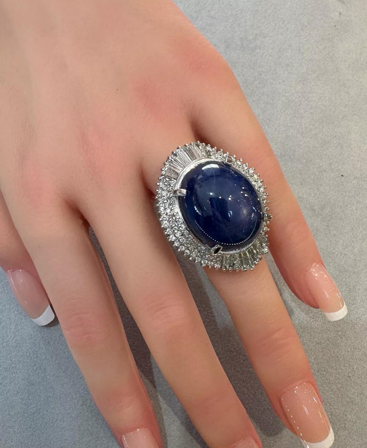 Natural 54 carat Star Sapphire and Diamond Ballerina Ring in Platinum

Large Star Sapphire and Diamond Ring features a Natural Blue Oval Cabochon Star Sapphire weighing 54.34 carats surrounded by Natural Round Brilliant and Baguette Diamonds in a