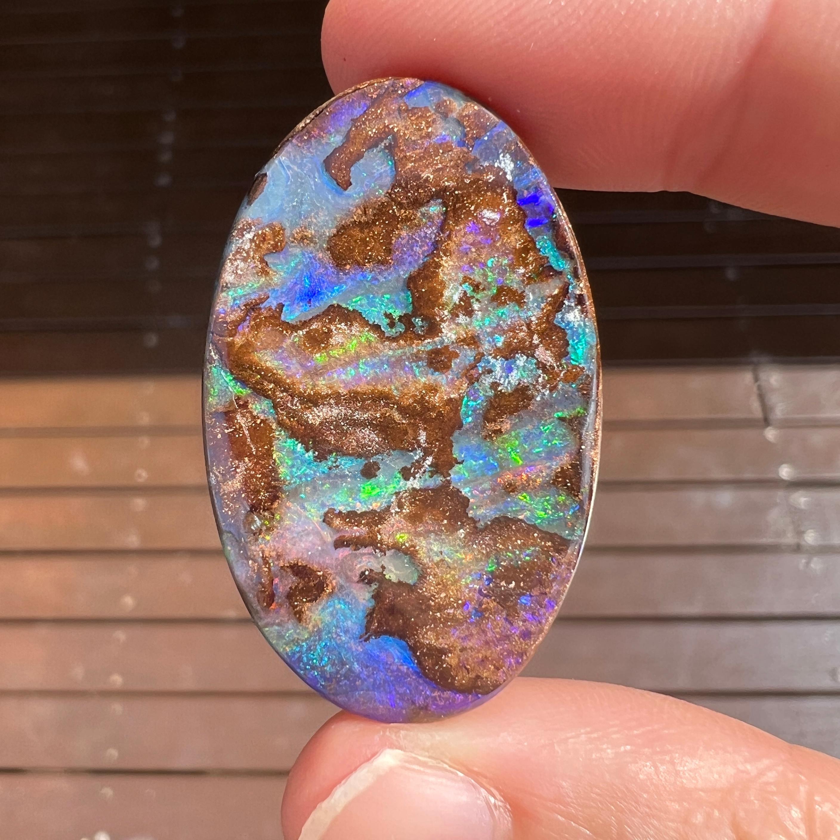 Cette belle opale australienne de 56,64 ct a été extraite par Sue Cooper dans sa mine d'opales de Yaraka, dans l'ouest du Queensland, en Australie, en 2024. Sue a traité elle-même l'opale brute et l'a découpée en une grande forme ovale. Nous aimons
