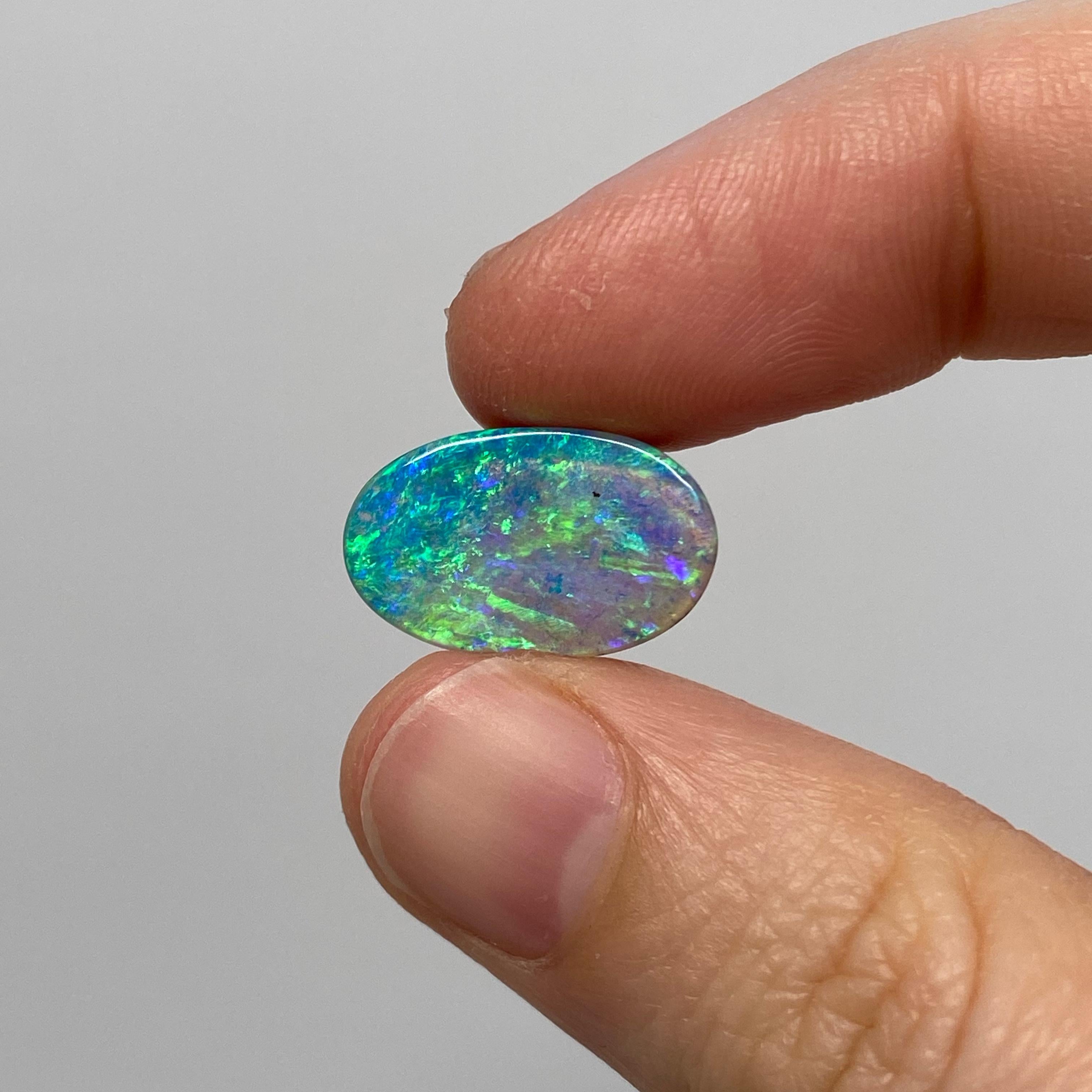This natural solid oval Australian boulder opal was mined in western Queensland, Australia by a female opal miner. It has bright electric ocean colors that include sea green, turquoise and aquamarine. It has a lighter (N7) body tone (i.e.