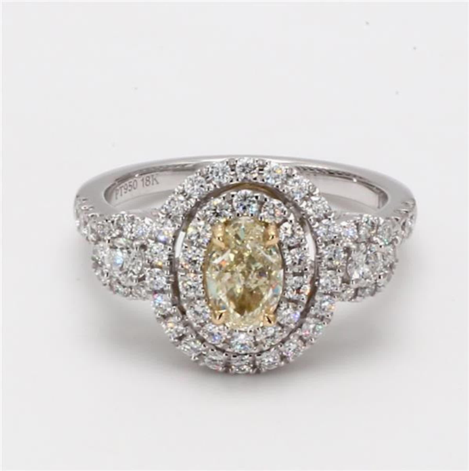 RareGemWorld's classic diamond ring. Mounted in a beautiful 18K Yellow and White Gold and Platinum setting with a natural oval cut yellow diamond. The yellow diamond is surrounded by round natural white diamond melee. This ring is guaranteed to