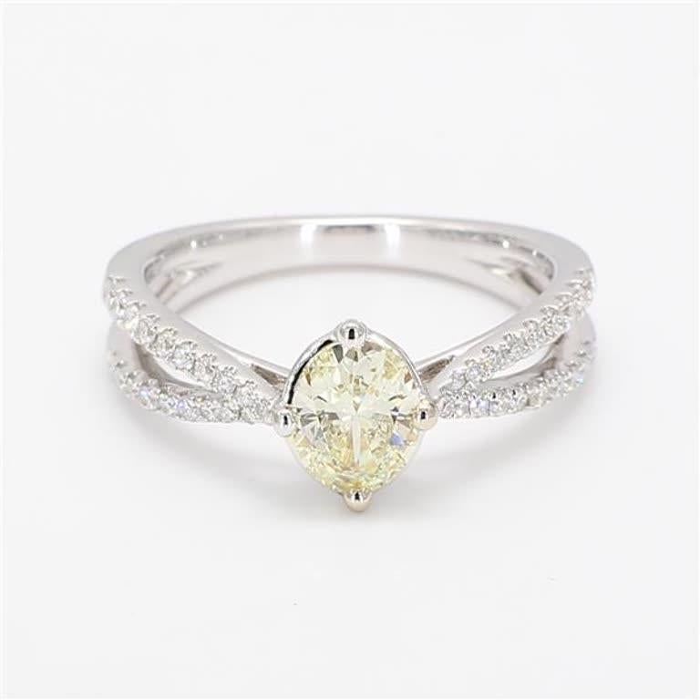 RareGemWorld's classic diamond ring. Mounted in a beautiful 18K Yellow and White Gold setting with a natural oval cut yellow diamond. The yellow diamond is surrounded by round natural white diamond melee. This ring is guaranteed to impress and