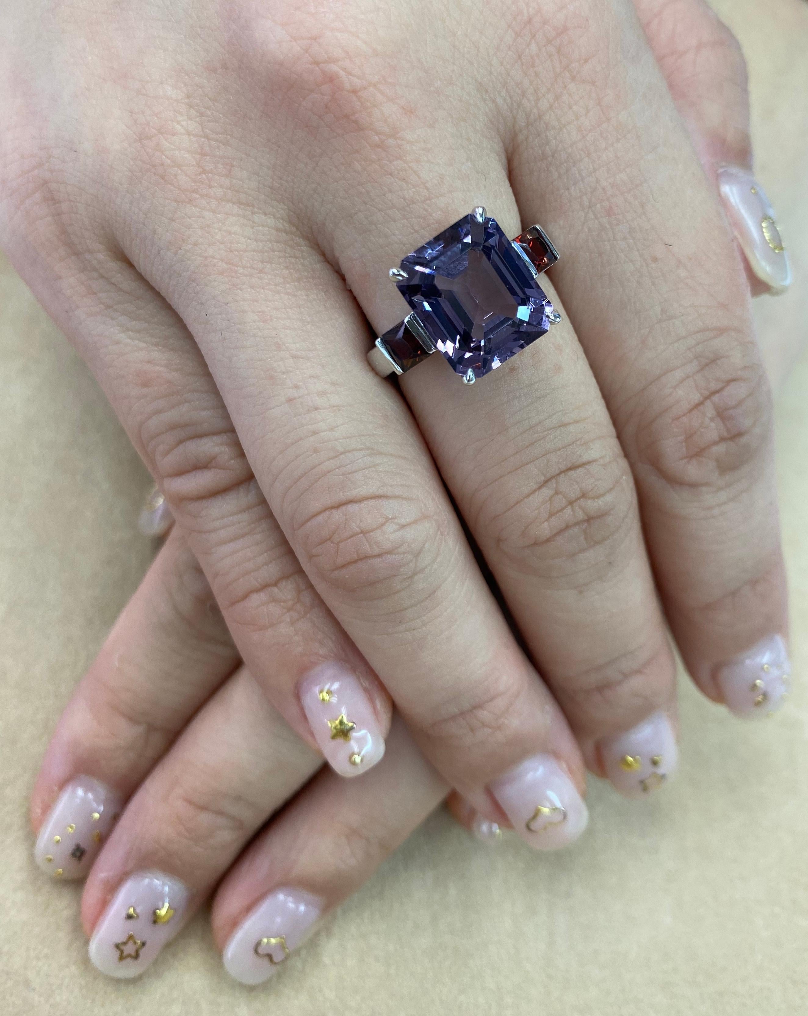 Here is a PURE Spinel 3 stone cocktail ring. The ring is set in 18k white gold. The center step cut purple pastel spinel is 7.77 cts. The Natural Spinel is well cut. The color is crispy and almost loupe clean. On each sides of the center spinel are