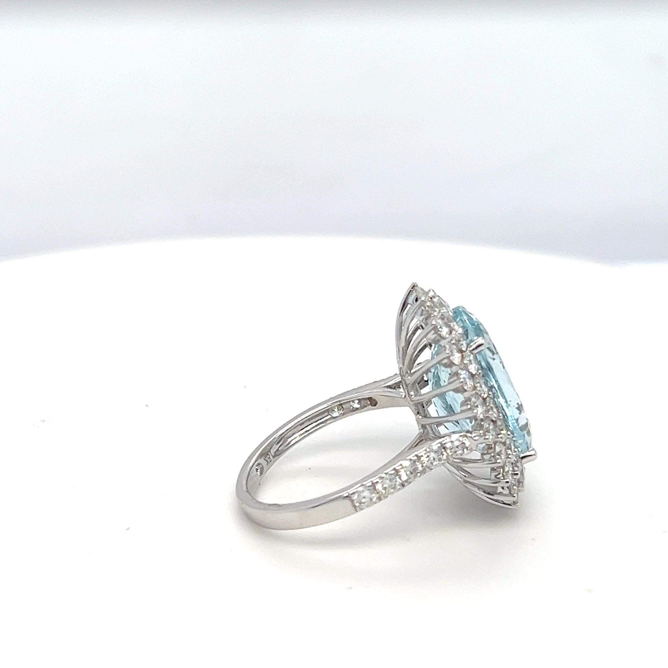 This elegant ring features an 8.81-carat oval aquamarine, expertly hand-cut and polished for a stunning, eye-clean appearance. The center stone is surrounded by a 2.21-carat halo of sparkling diamonds, creating a captivating design. Beautifully