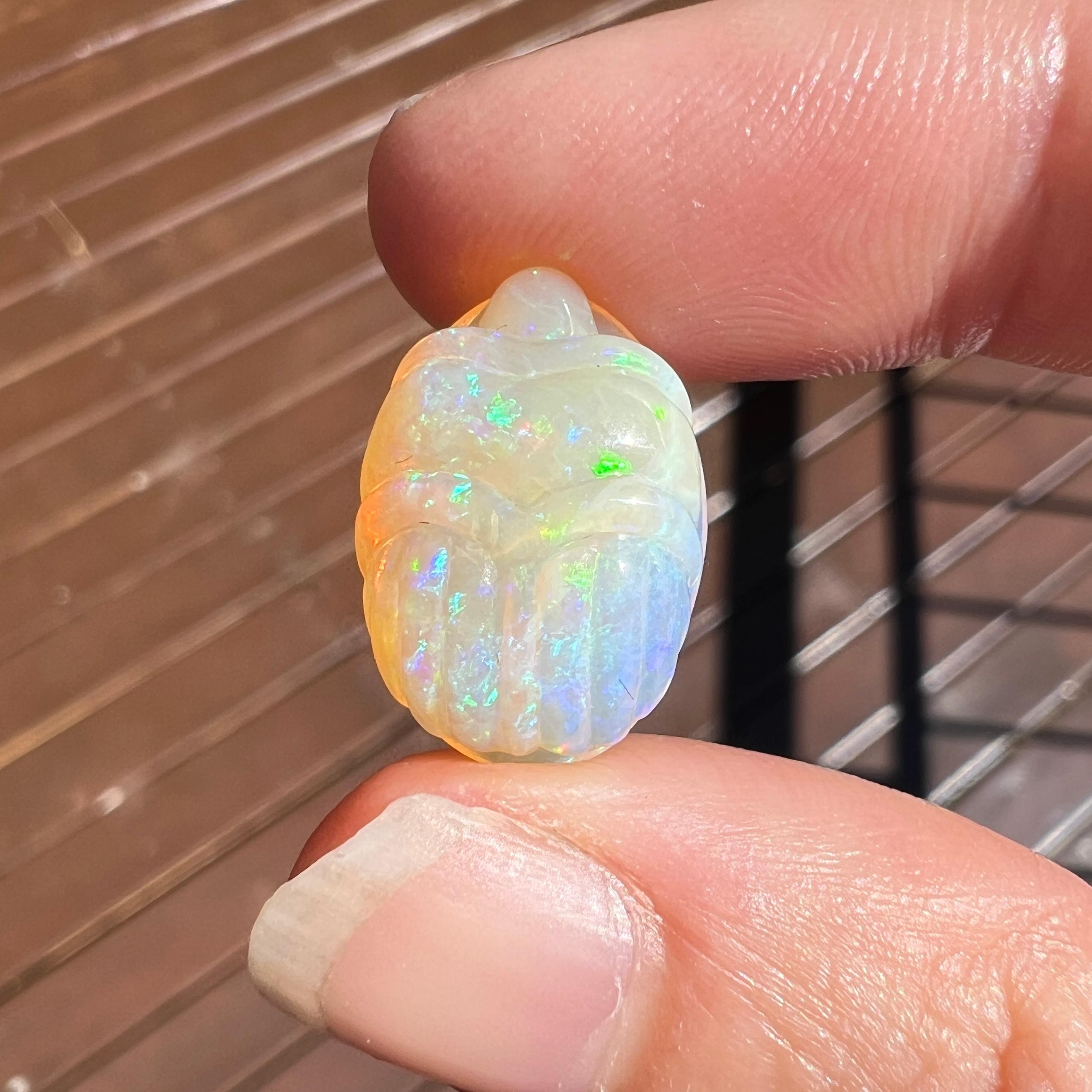 This beautiful 9.35 Ct Australian crystal opal was mined by Sue Cooper at her Russells opal mine in western Queensland, Australia in 2024. Sue processed the rough opal herself and selected it to be carved into a scarab. 

The opal's size of