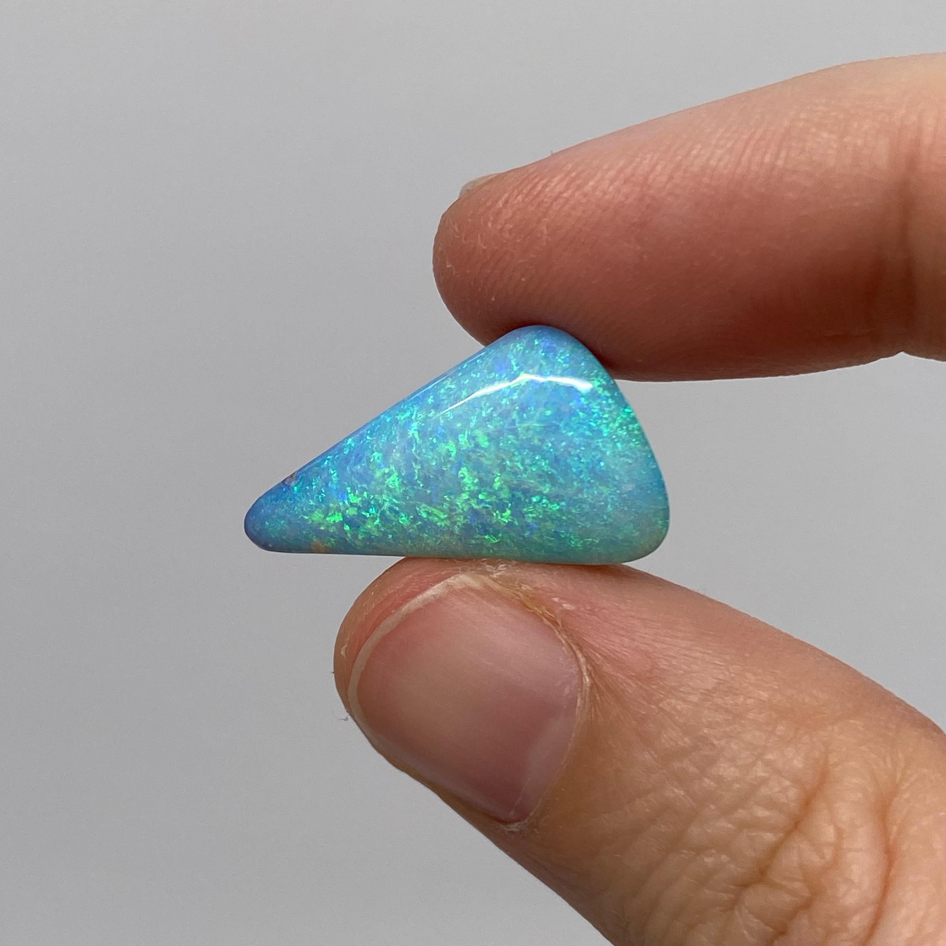 Cette opale naturelle solide de forme libre a été extraite dans l'ouest du Queensland, en Australie, par une opératrice de mines d'opales. Il présente de superbes couleurs d'océan tropical, dont le turquoise et l'aigue-marine. Il est très brillant