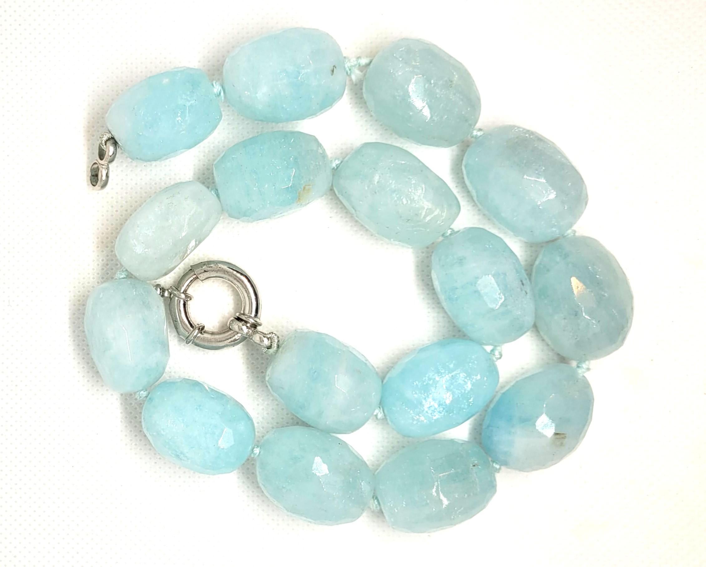 This 18-inch natural aquamarine necklace features sixteen oval-shaped aquamarines, each measuring 25 x 19 x 16 mm, with a total weight of approximately 950 carats. The necklace is knotted and secured with a silver 925 toggle clasp. The necklace