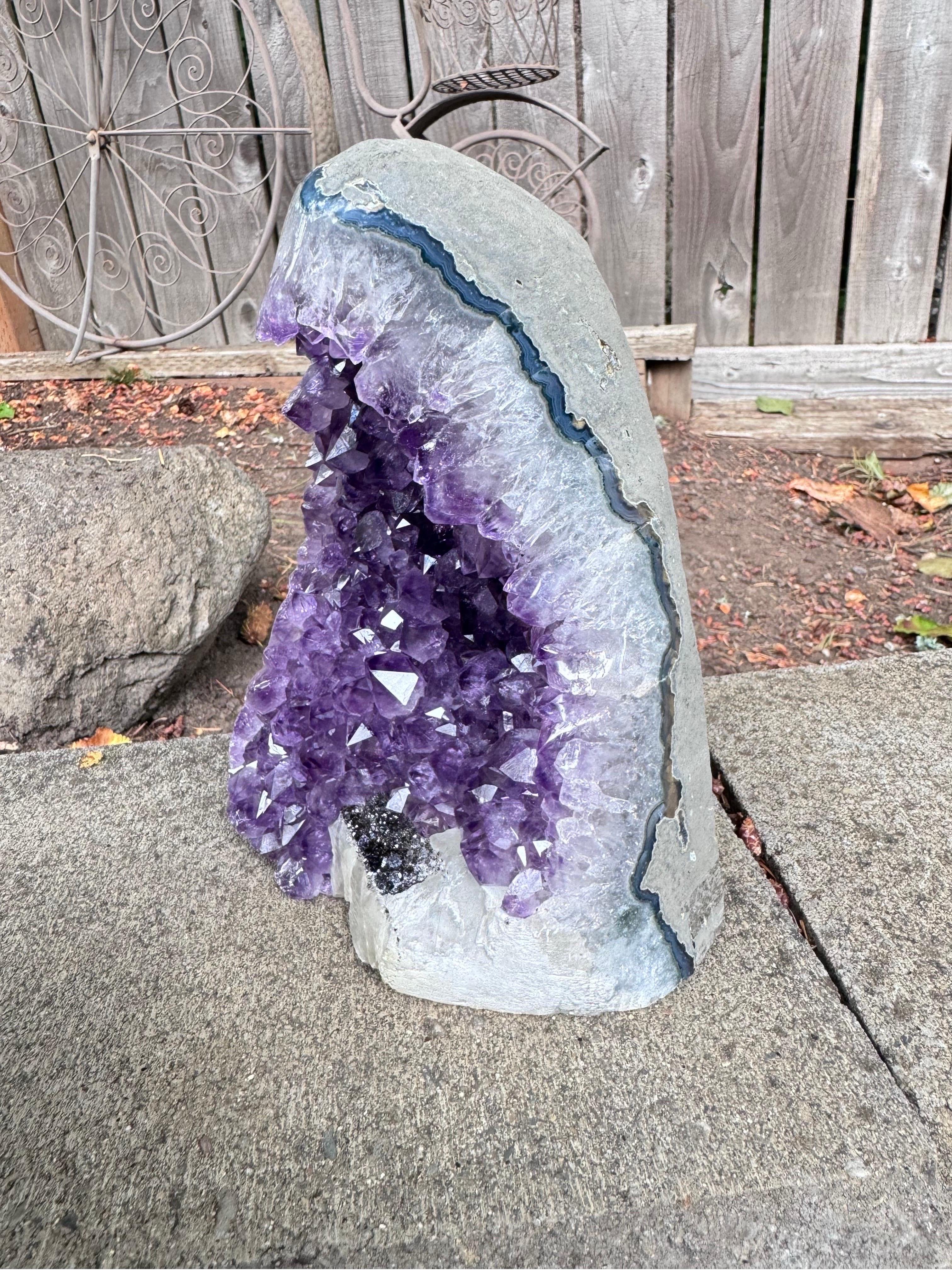 Experience the natural beauty and calming energy of this stunning amethyst geode, sourced from the picturesque landscapes of Uruguay. Unlike many Brazilian amethysts, which are often held together with cement, this remarkable Uruguayan piece is