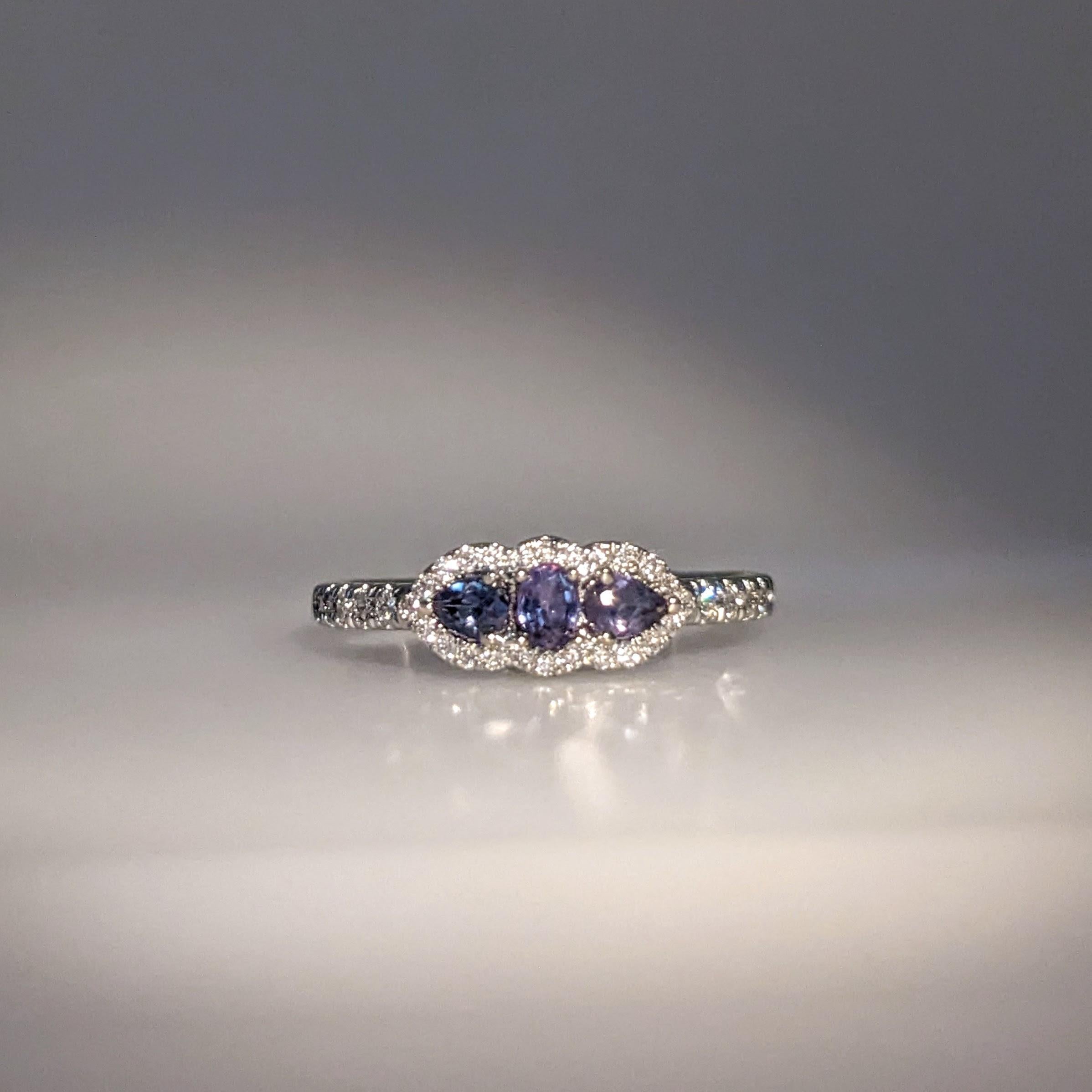 This beautiful ring features 3 alexandrites of 0.34 carat weight with natural earth mined diamonds set in soid 14K gold. This color changing alexandrite is a green/blue color in daylight with hints of purple that get more prominent in candlelight