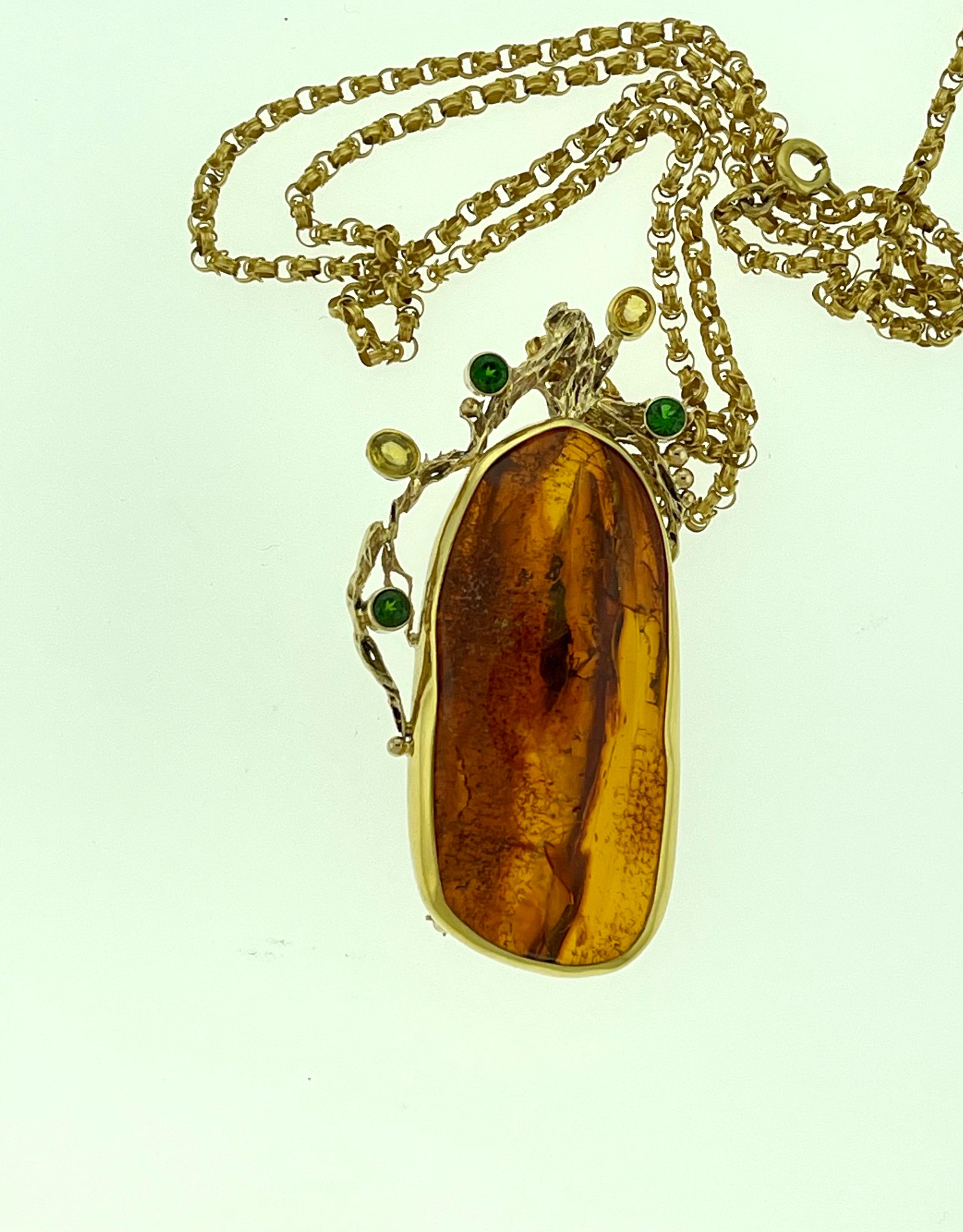 Approximately 80 Ct Natural Amber Tsavorite & Yellow Sapphire Necklace / Pin 18 Karat Yellow Gold 

Beautiful intense color Of amber
It has a bail for chain and clip to be used as pin
Beautiful 18 K solid gold frame 
Comes with a 18 Karat yellow