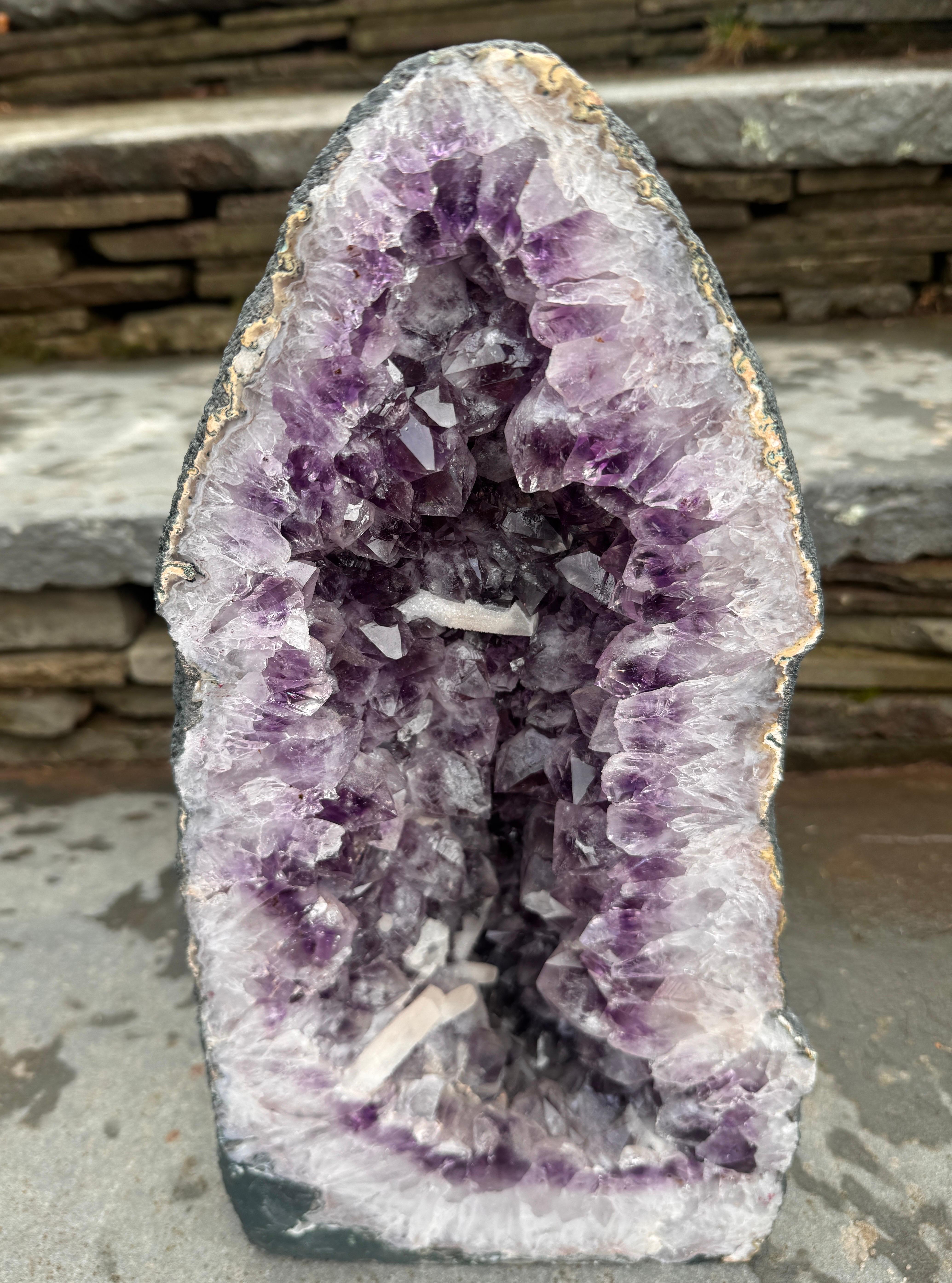 The product is a stunning 33.5 LB large natural amethyst geode cathedral crystal cluster. This unique piece is a beautiful representation of nature's artistry, with its natural shape and intricate crystal formations. Ideal for collectors or those