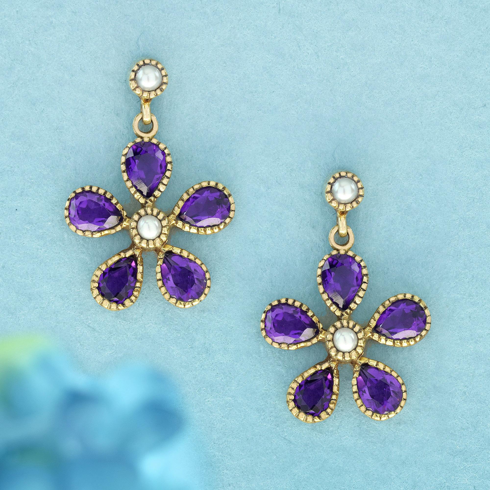 Diese Vintage-inspirierten Ohrringe zeigen ein florales Design mit vier birnenförmigen violetten Blütenblättern aus Amethysten in einer gelbgoldenen Migränearbeit und einer runden weißen Perle in der Mitte, die an Blütenstaub erinnert. Die zeitlose