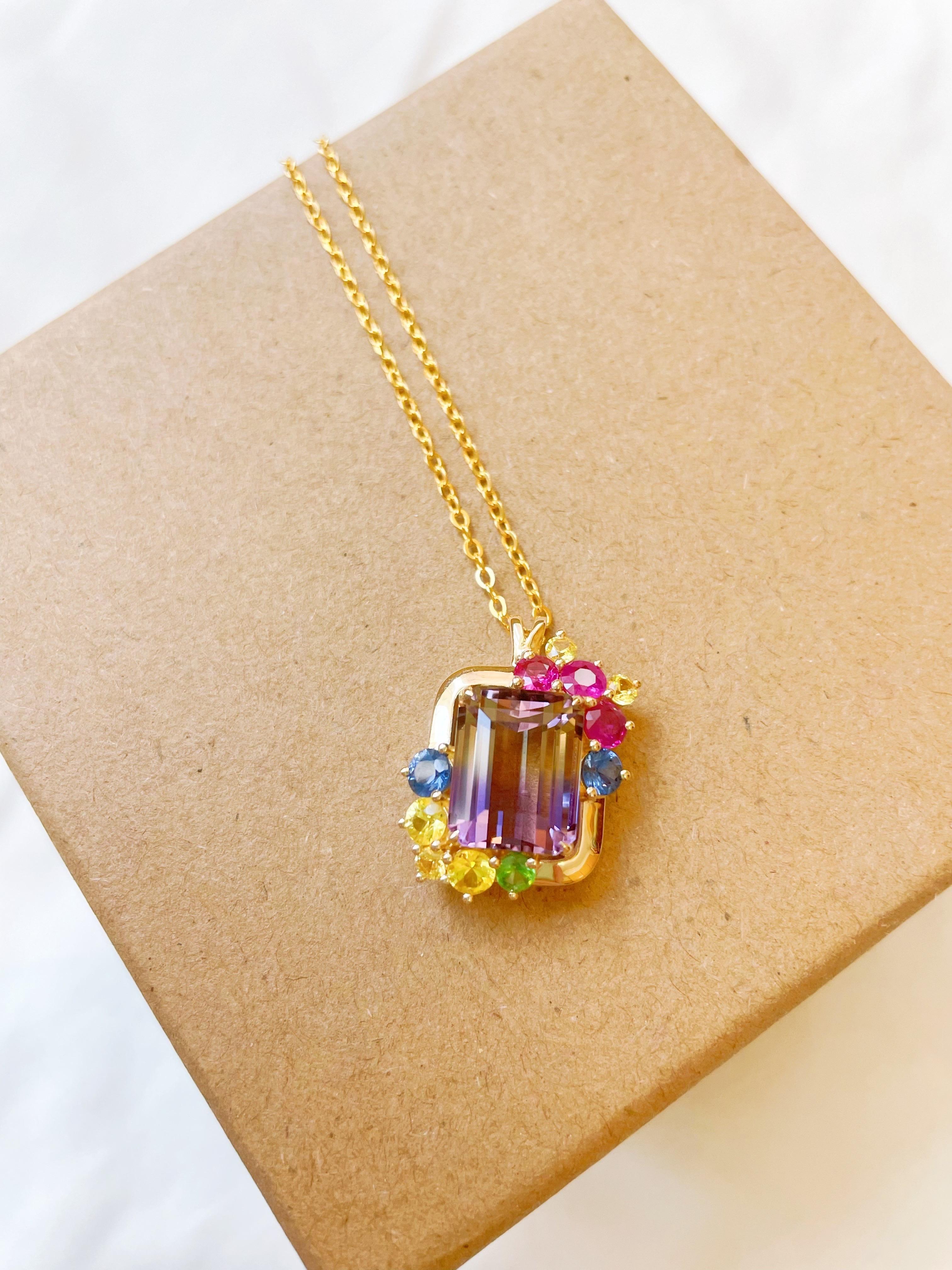 Ce pendentif conçu sur mesure est orné de saphirs naturels colorés et de tsavorites. Le design simple et moderne s'adapte à toutes les tenues de la garde-robe. L'amétrine naturelle au centre mesure 5,55 carats et présente un gradient de couleur