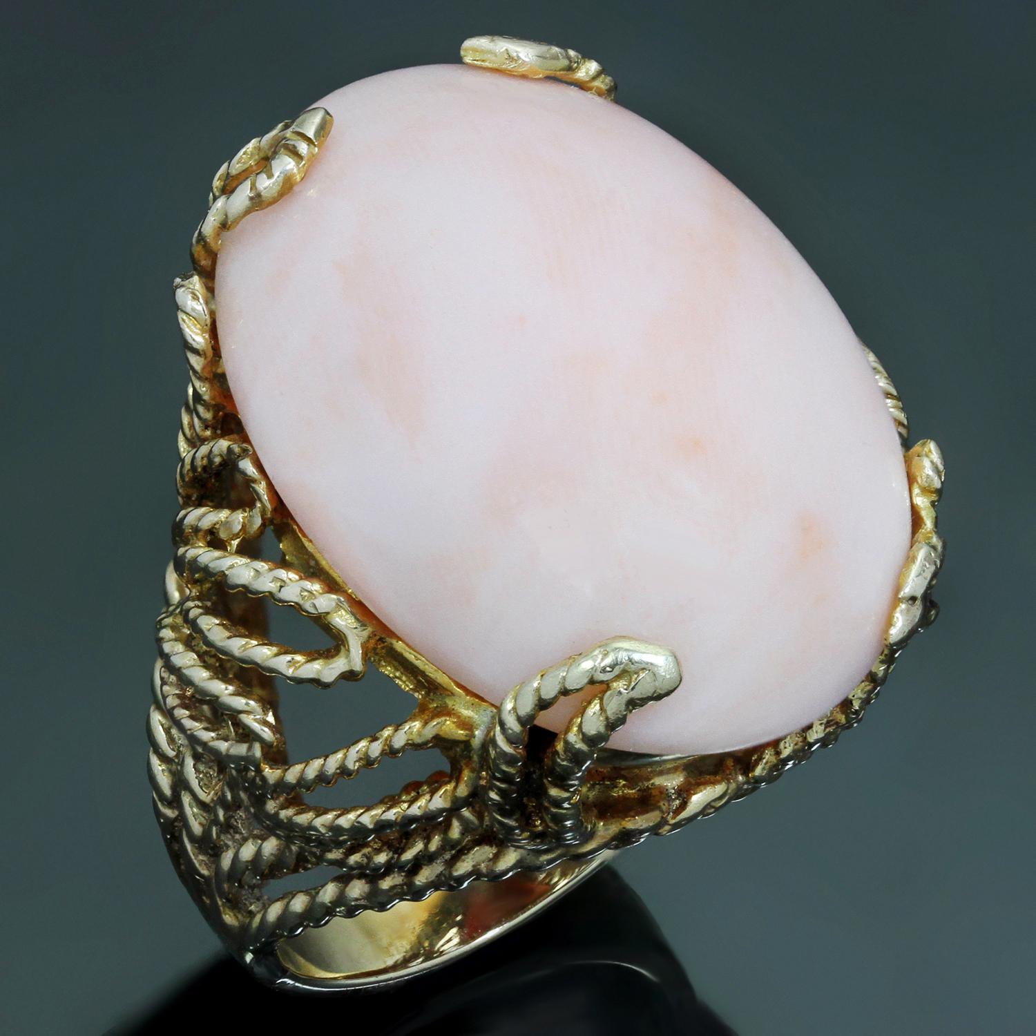 This classic retro vintage ring is hand-crafted in 14k yellow gold and set with a natural angel skin pink coral measuring 21.0mm x 29.0mm. Made in United States circa 1960s. Measurements: 1.06