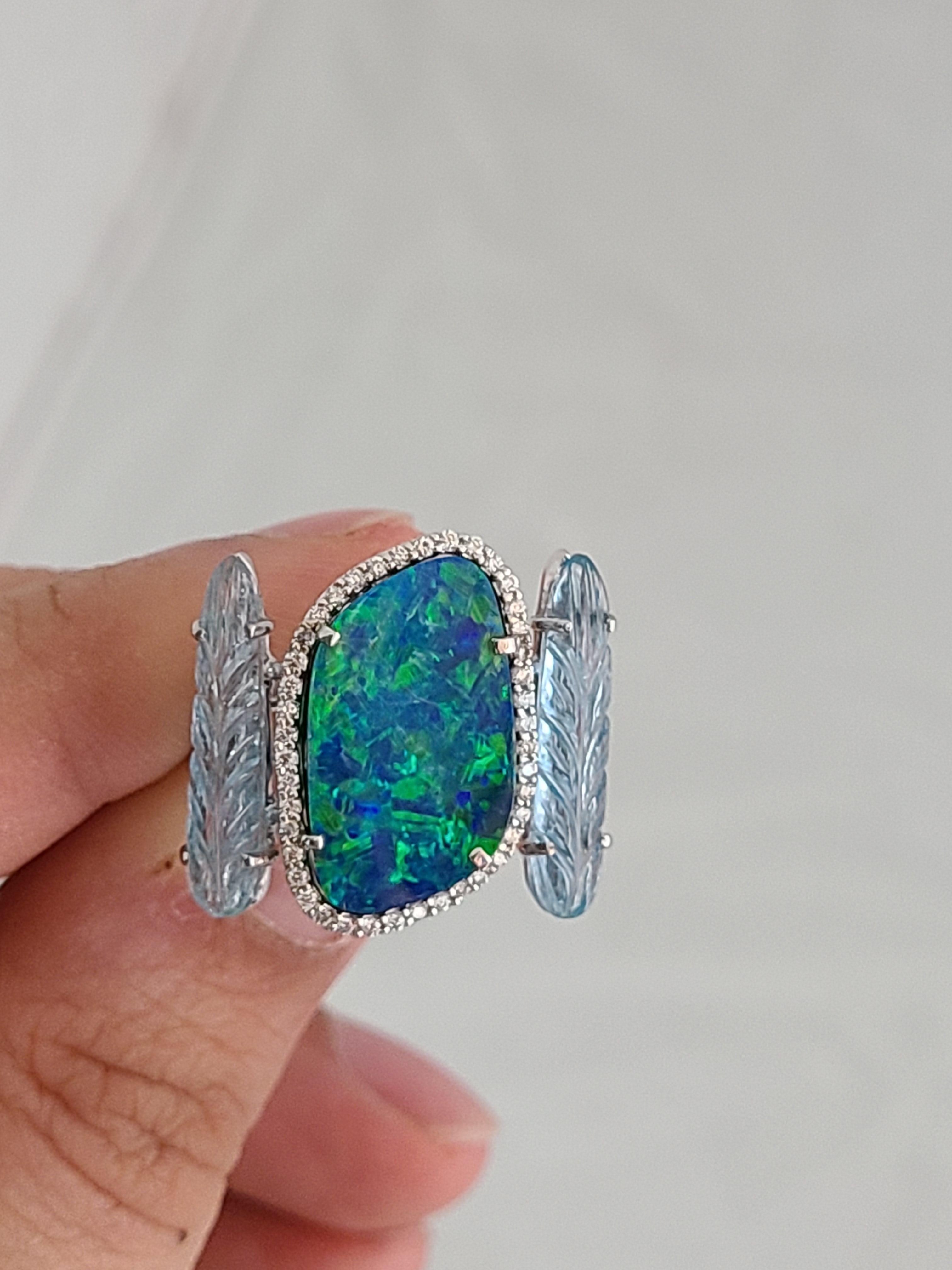 A modern and chic opal doublet and aquamarine ring with diamonds set in 18k gold. The opal weight is 4.75 carats and carved aquamarine weight is 3.8 carats . The diamond weight is .23 carats, ring dimensions in cm 2.2 x 2.2 x 2.4 (LXWXH). US size 6
