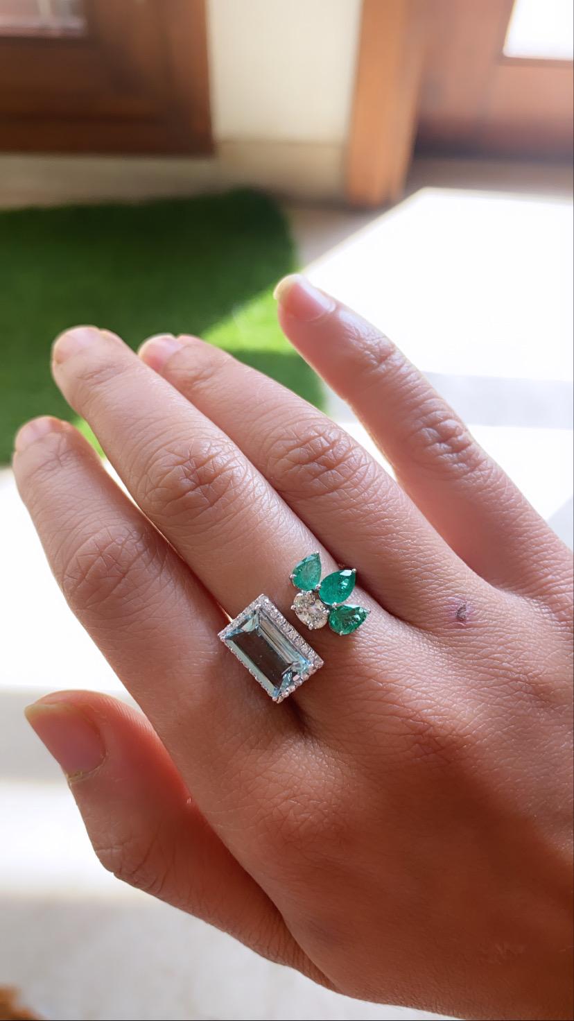 A beautiful and modern natural aquamarine , emerald and diamond ring set in 18k white gold. The Aquamarine weight is 2.33 carats , emerald weight is 1.25 carats, Diamond oval weight is .37 carats and other small diamond weight is .22 carats. The net