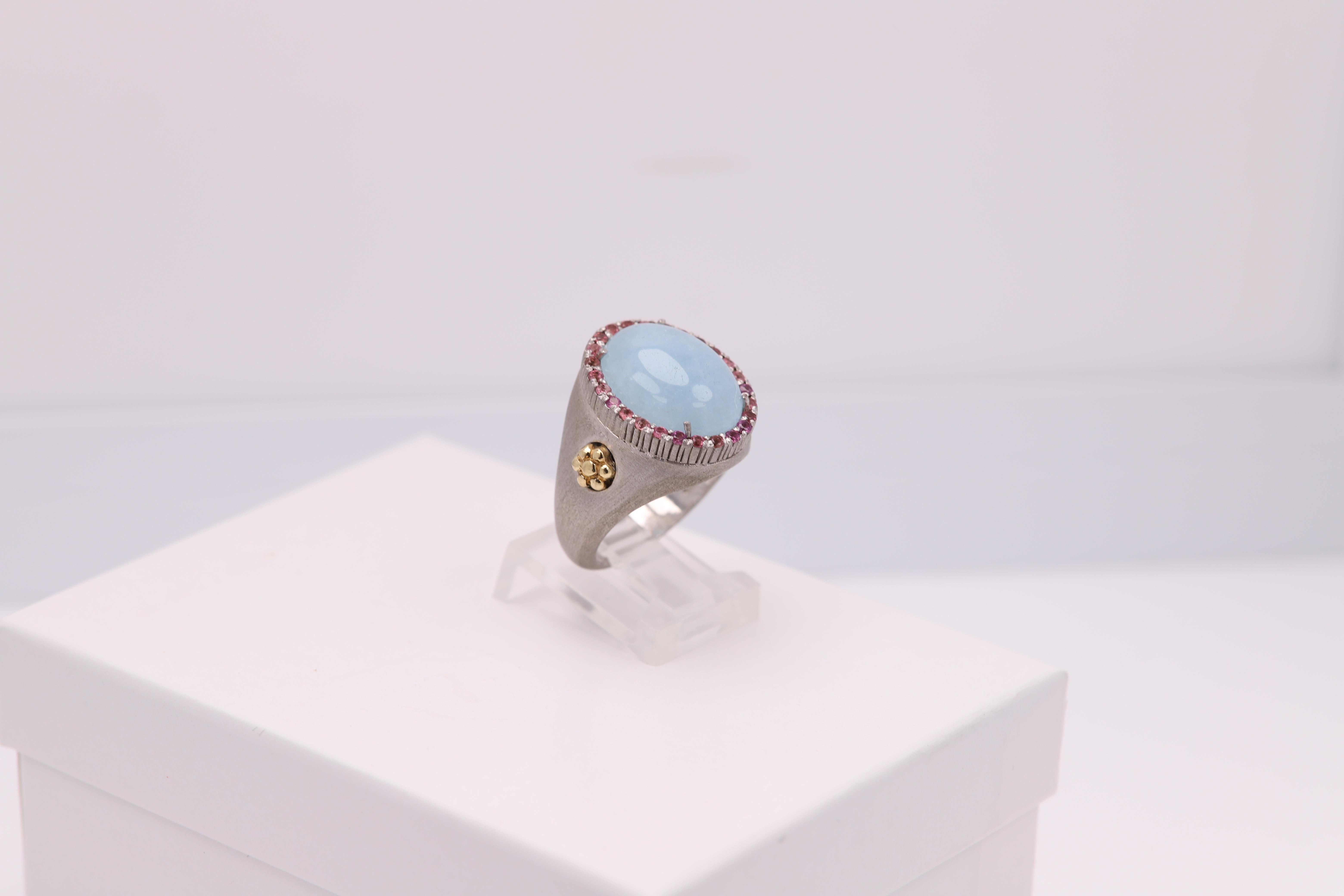 Vintage Ring with a Brilliant Aquamarine stone
and small pink Tourmaline  stones - all natural.
Aquamarine is Cabochon cut.
Approx size 16 x 12 mm
Well craftsmanship - made in Italy
Mostly Sterling Silver 925 and the side flowers are solid 18k