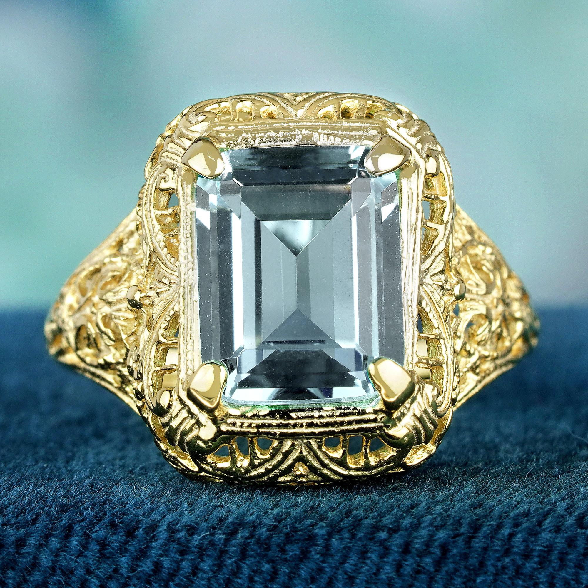 Dive into elegance with our Aquamarine Vintage Style Filigree Ring in yellow gold. Adorned with a captivating emerald-cut aquamarine stone, its serene aqua blue hue mesmerizes the senses. Crafted with intricate filigree detailing, this ring exudes