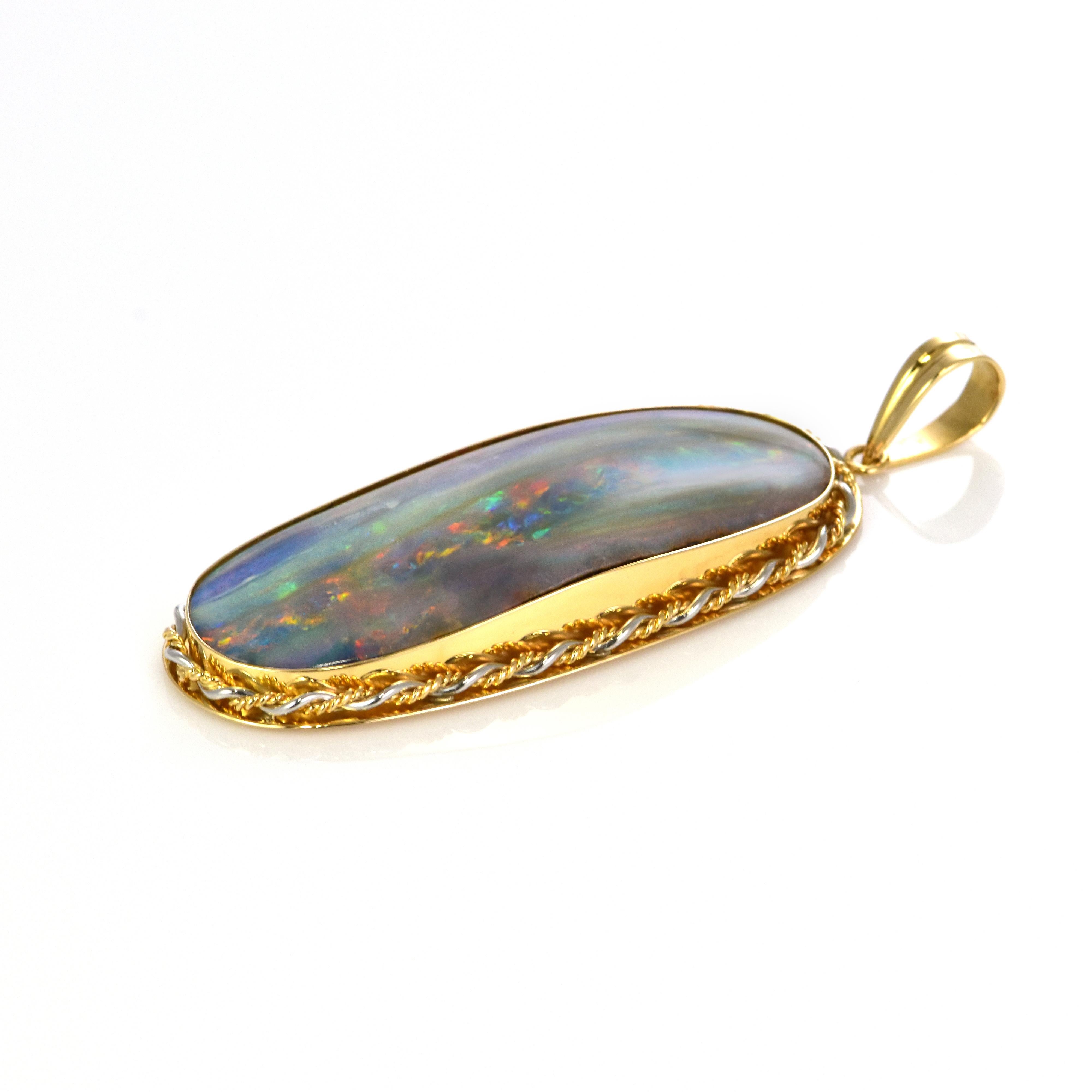 Un bellissimo ciondolo con Opale Boulder australiano e diamanti, realizzato in oro 18 carati e platino. L'Opale mostra un ottimo gioco di colori! Gli opali sono noti per la presenza di lampi di colori dell'arcobaleno, noti come 
