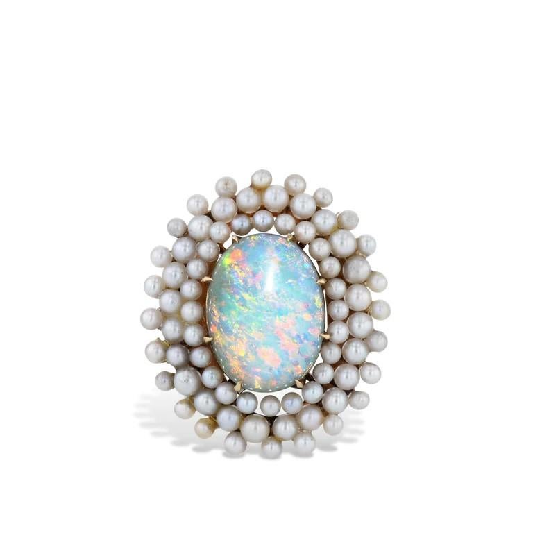 Gorgeous and timeless, this 14kt Yellow Gold Natural Australian Opal Estate Ring is a captivating accessory.

Boasting a spectacular natural oval Australian opal, and three rows of sparkly saltwater seed pearls, this piece from the 1940's Estate and
