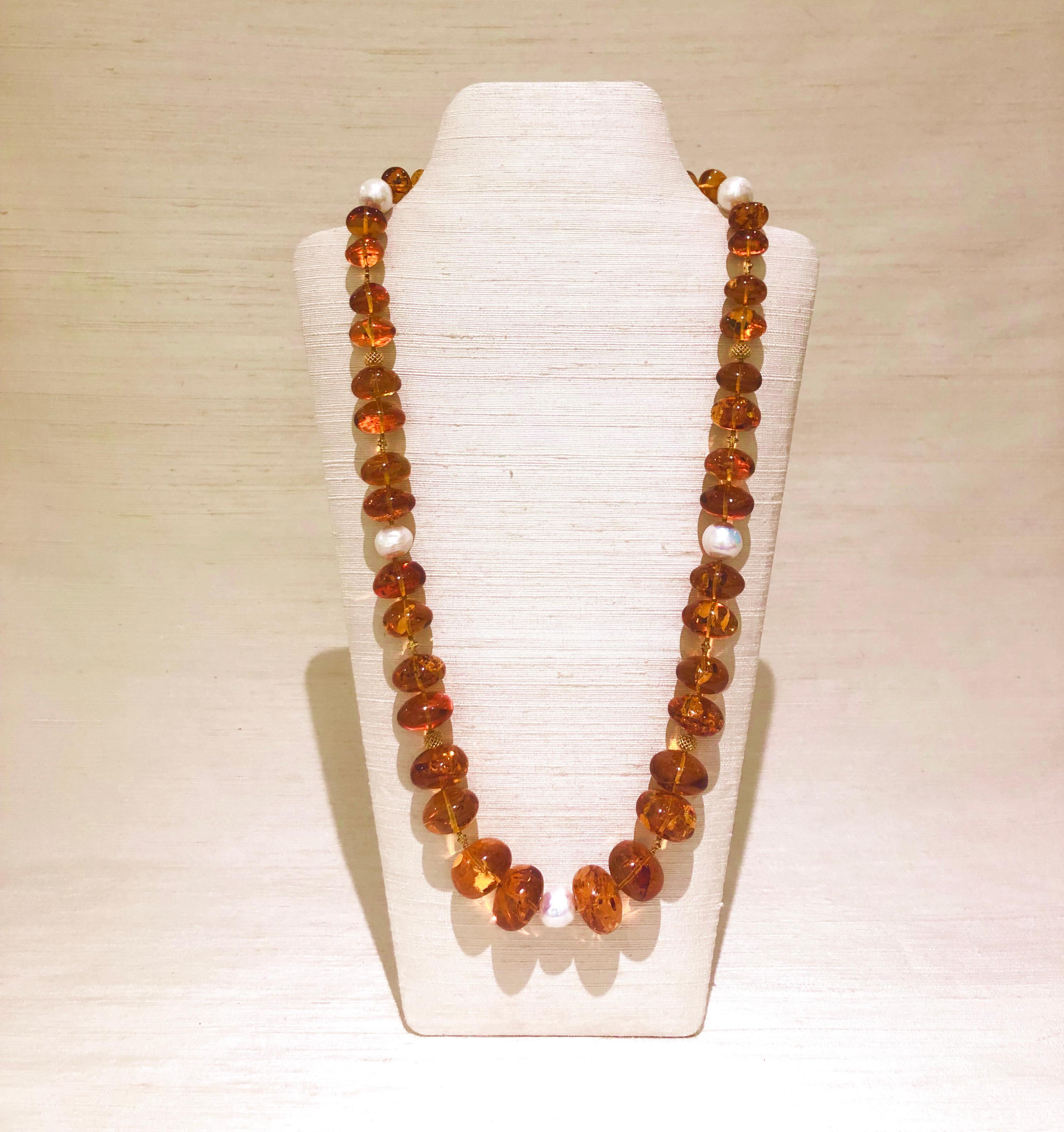 This charming long necklace of large graduated Baltic honey amber beads is mixed with Baroque Fresh Water Pearls and handcrafted Indian 18 karat decorative gold beads with an S-form clasp.
Baltic amber is fossilized tree sap and millions of years