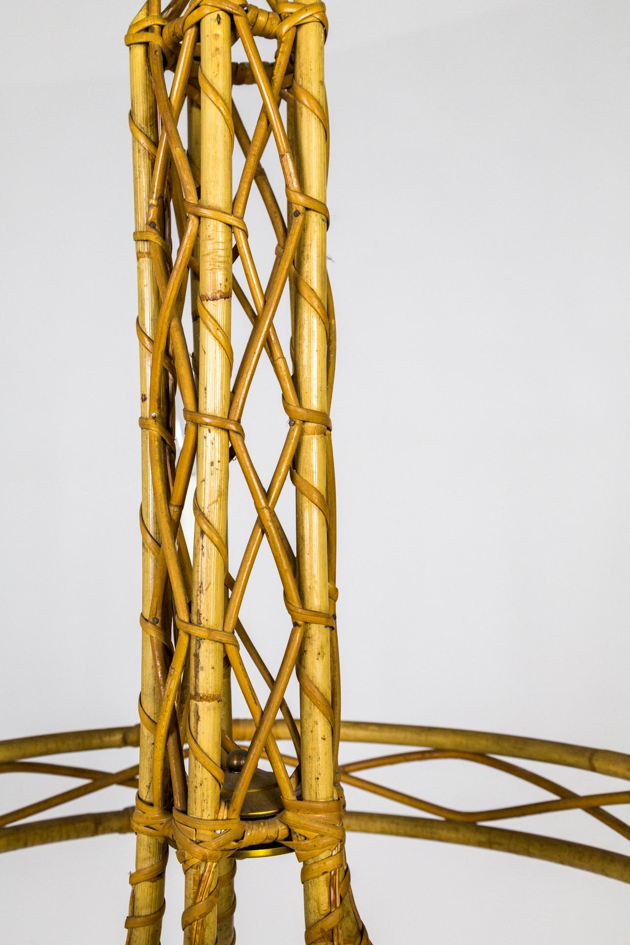 A 5-light, handmade chandelier made from bent bamboo pieces sweeping out and up, held by a bamboo ring structure. It's bound and decorated with woven rattan cane strips and zig-zagging, slender bamboo between the larger ones.  It has small, wood