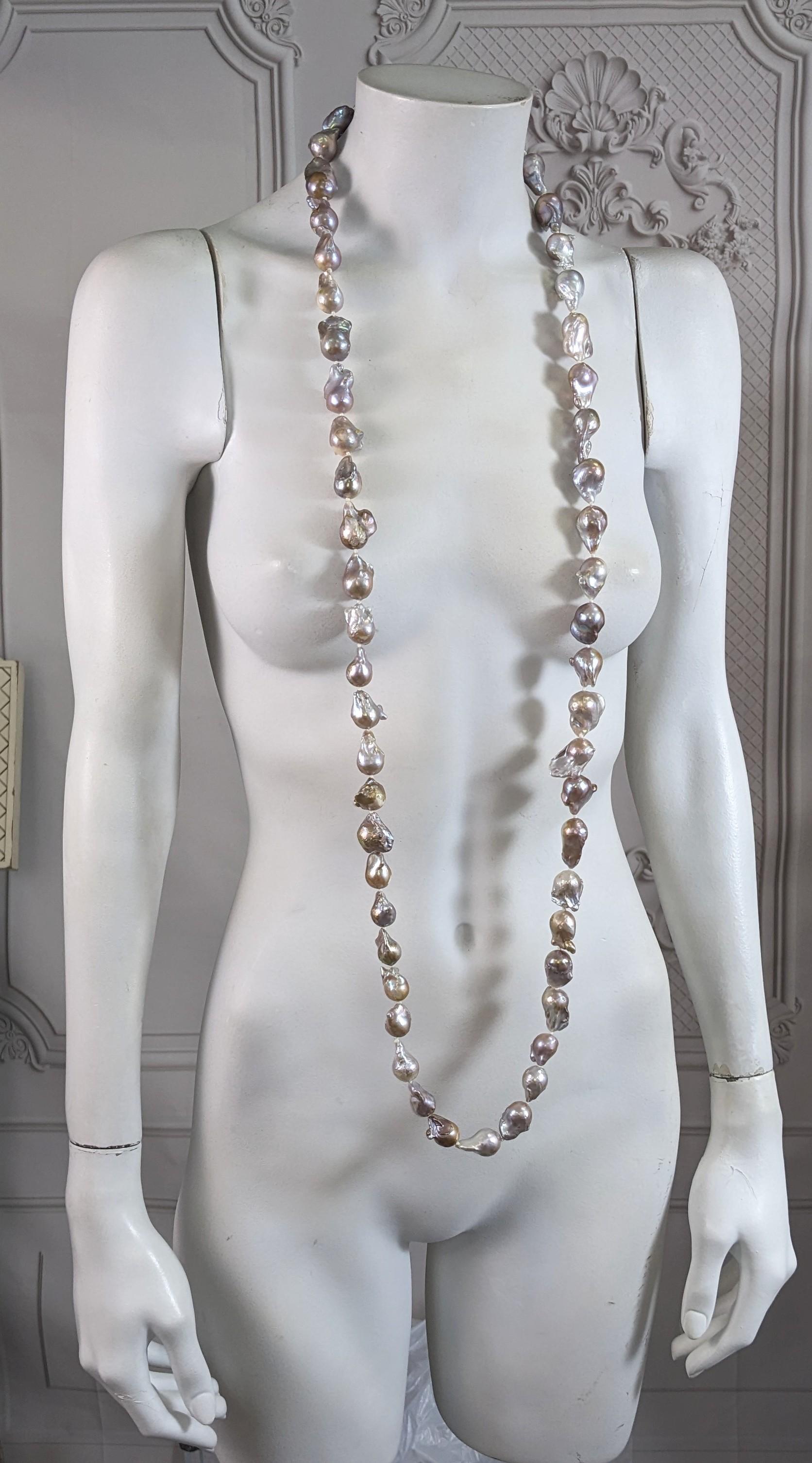 Elegant and impressive Natural Baroque Grey Pearl Long Necklace from the 1990's. Massive strand of natural freeformed baroque fresh water pearls are hand knotted in an endless configuration. Primarily grey with tones of brownish rose lustre. 
Super
