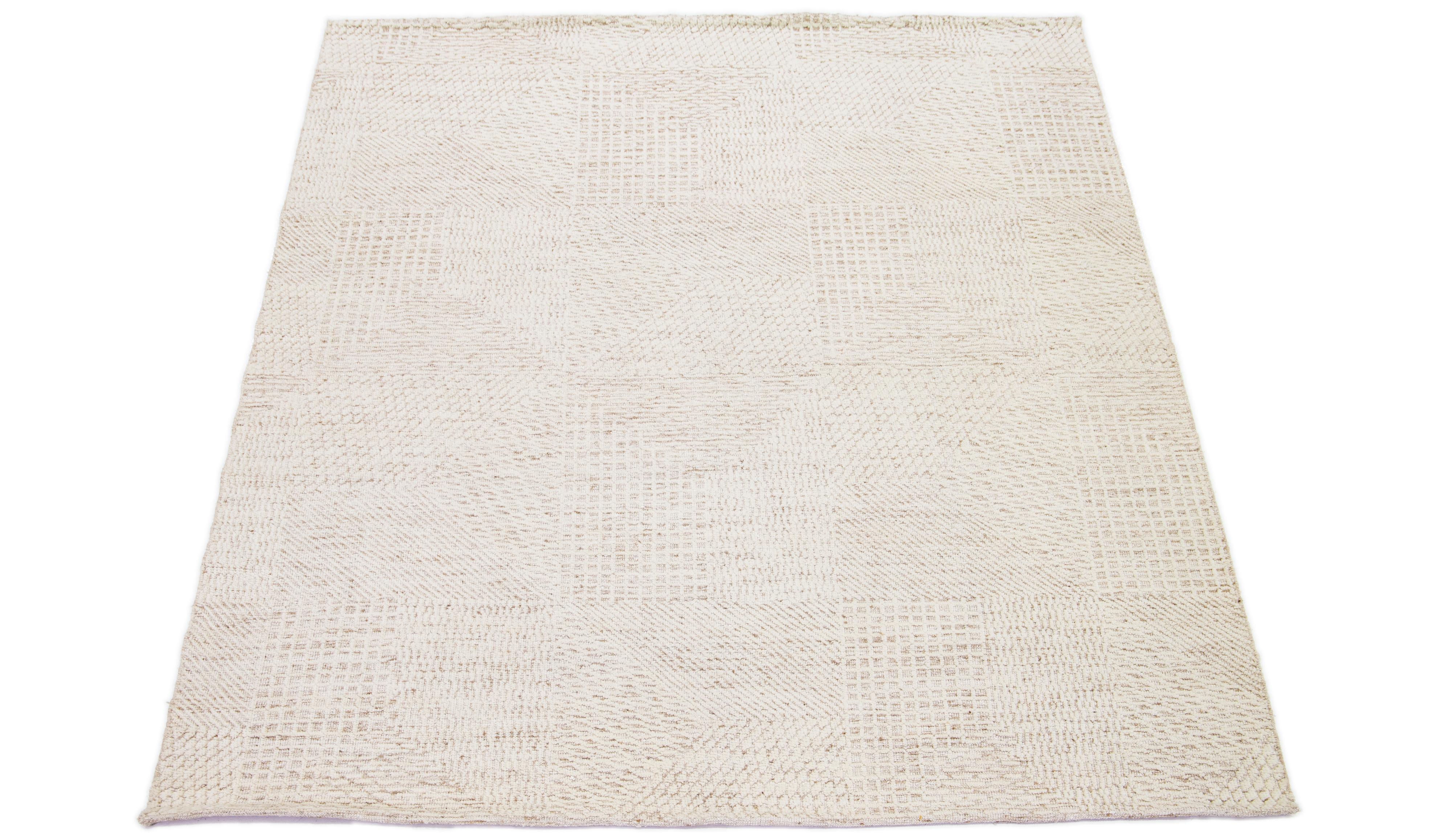 This hand-knotted wool rug showcases a modern Moroccan-inspired motif highlighting understated natural beige hues against a bold beige and brown foundation, creating a captivating abstract geometric pattern.

This rug measures 7'10