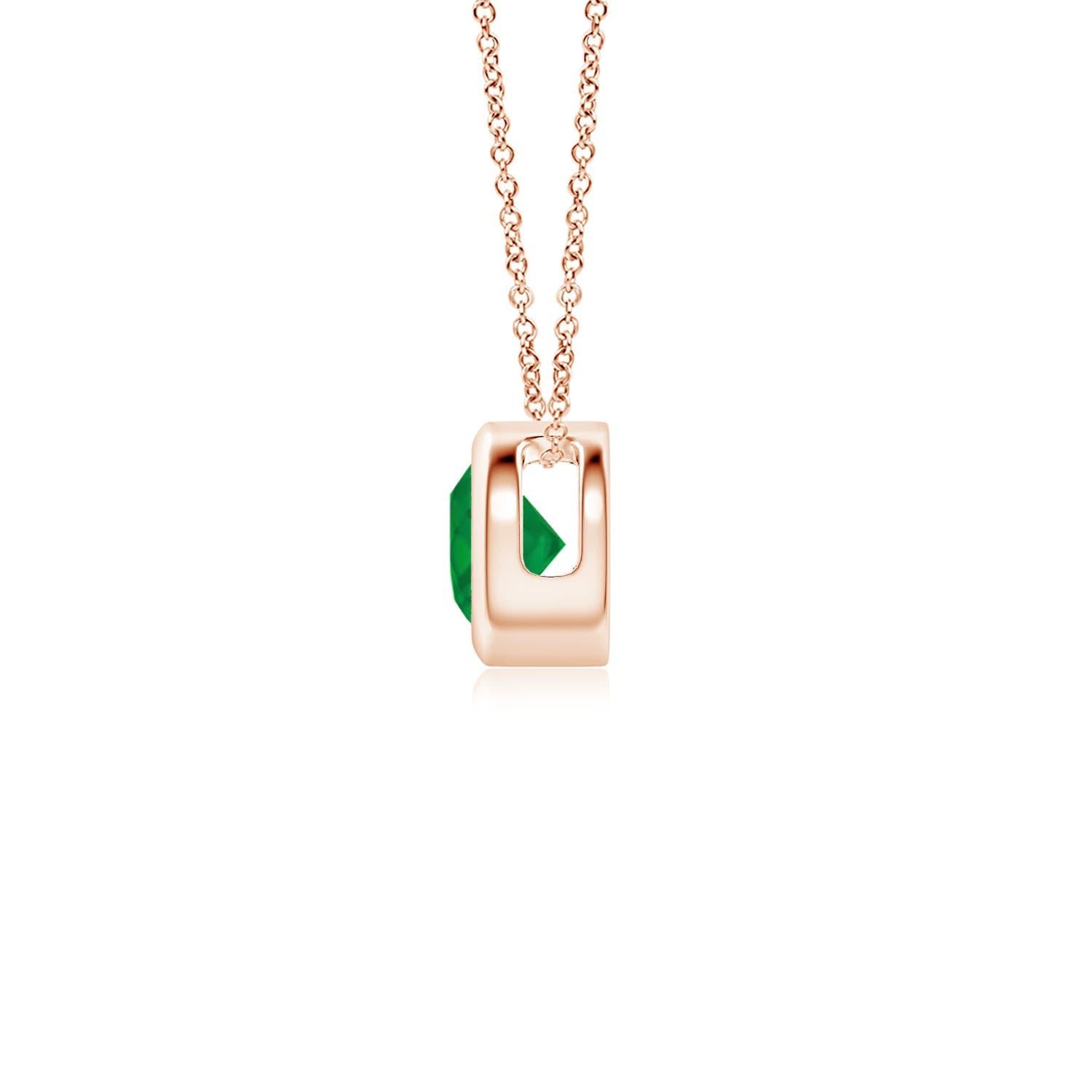 This classic solitaire emerald pendant's beautiful design makes the center stone appear like it's floating on the chain. The lush green emerald is secured in a bezel setting. Crafted in 14k rose gold, this round emerald pendant is simple yet