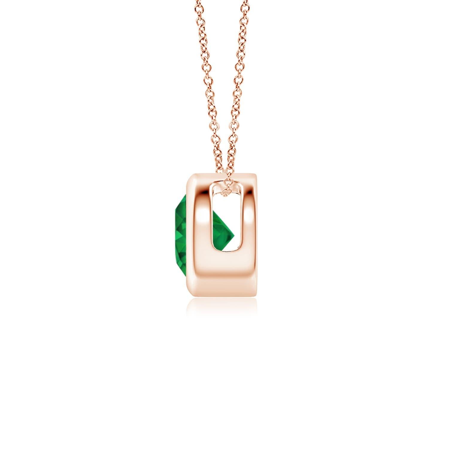 This classic solitaire emerald pendant's beautiful design makes the center stone appear like it's floating on the chain. The lush green emerald is secured in a bezel setting. Crafted in 14k rose gold, this round emerald pendant is simple yet