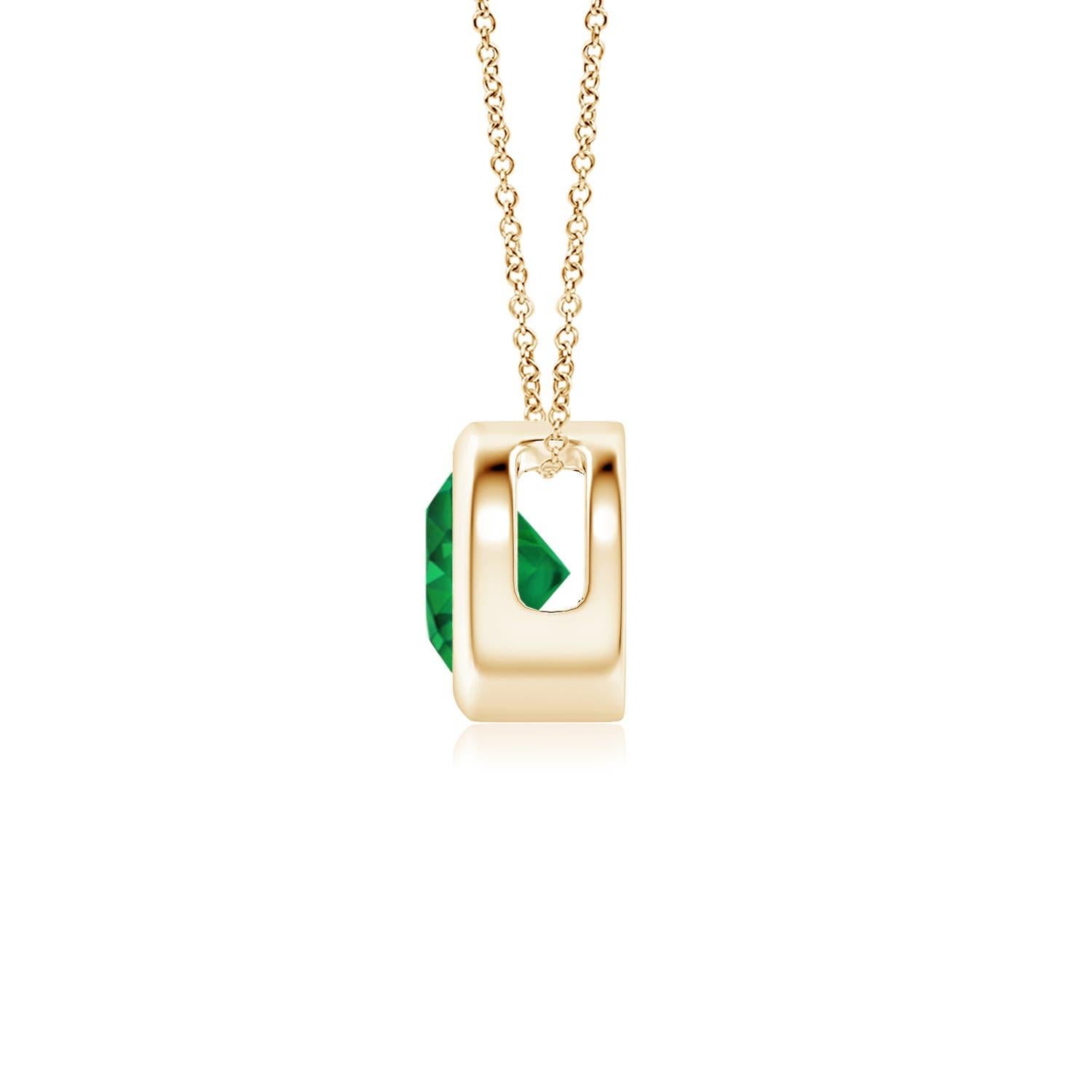 This classic solitaire emerald pendant's beautiful design makes the center stone appear like it's floating on the chain. The lush green emerald is secured in a bezel setting. Crafted in 14k yellow gold, this round emerald pendant is simple yet