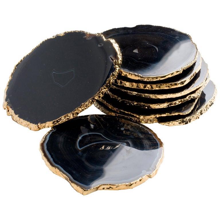 Stunning natural agate and crystal coasters with 24-karat gold plated edges. Gemstone coasters feature polished fronts and natural rough edges. No two pieces are alike. Makes a beautiful coffee table accessory and is a chic addition to any barware