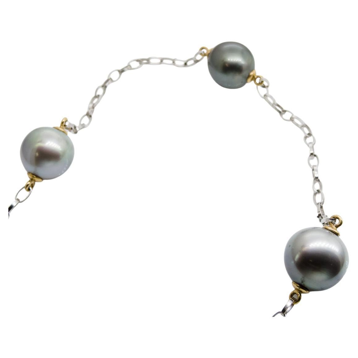 Long collier (61 cm=24 inch) avec 7 belles perles naturelles de Tahiti sur chaîne Belcher en or blanc 18 carats.
Les perles, coiffées d'or jaune 18 carats, ont un diamètre de 12 à 13 mm et sont de couleur grise à verte.
Le poids du collier est de