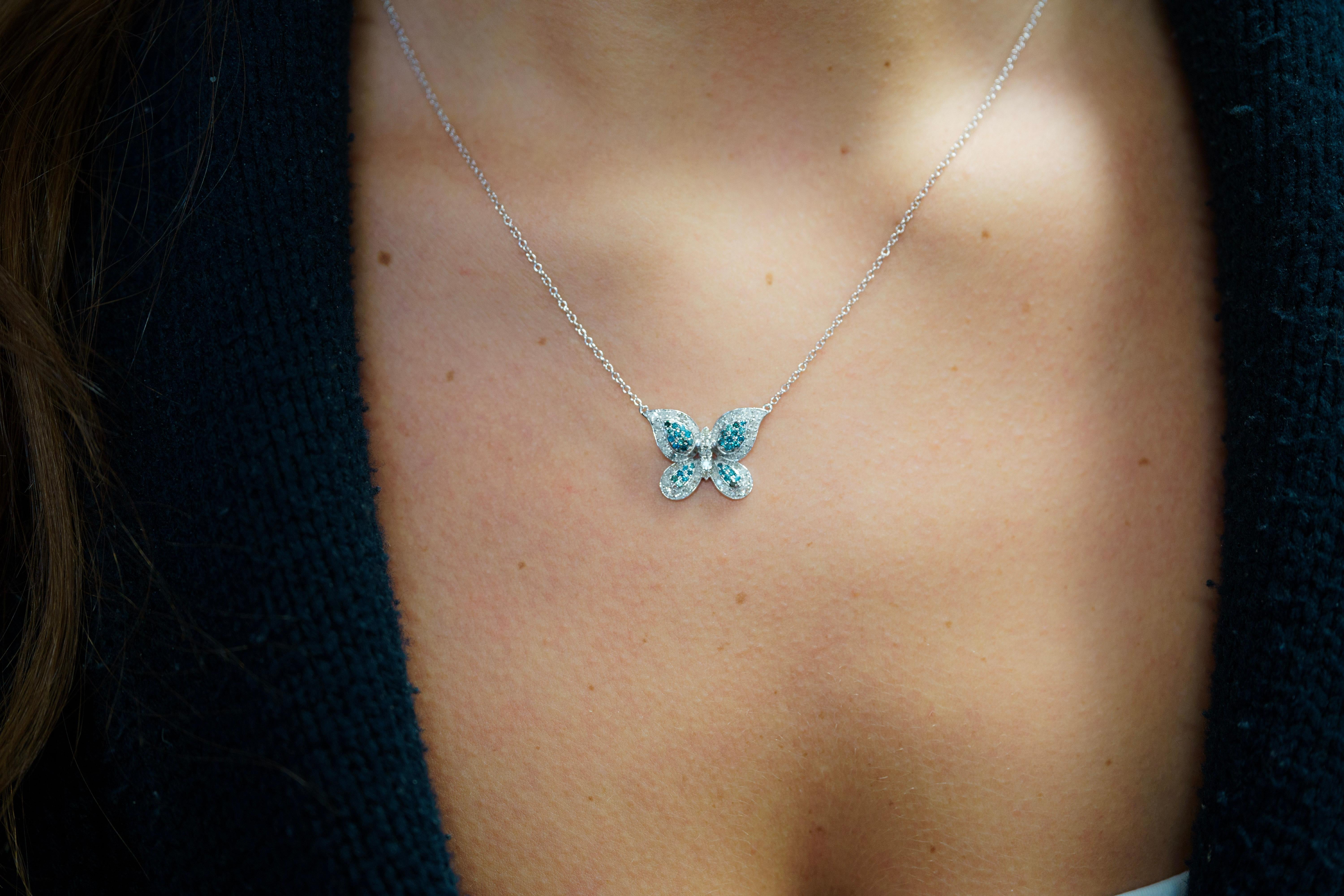 Natural Blue and White Diamond Butterfly Motif Cluster Pendant Necklace in 14K Solid White Gold. Fixed on a connecting double-bail setting that floats as it rests on the neck.

Featuring a wonderfully hand-set cluster of natural blue and white