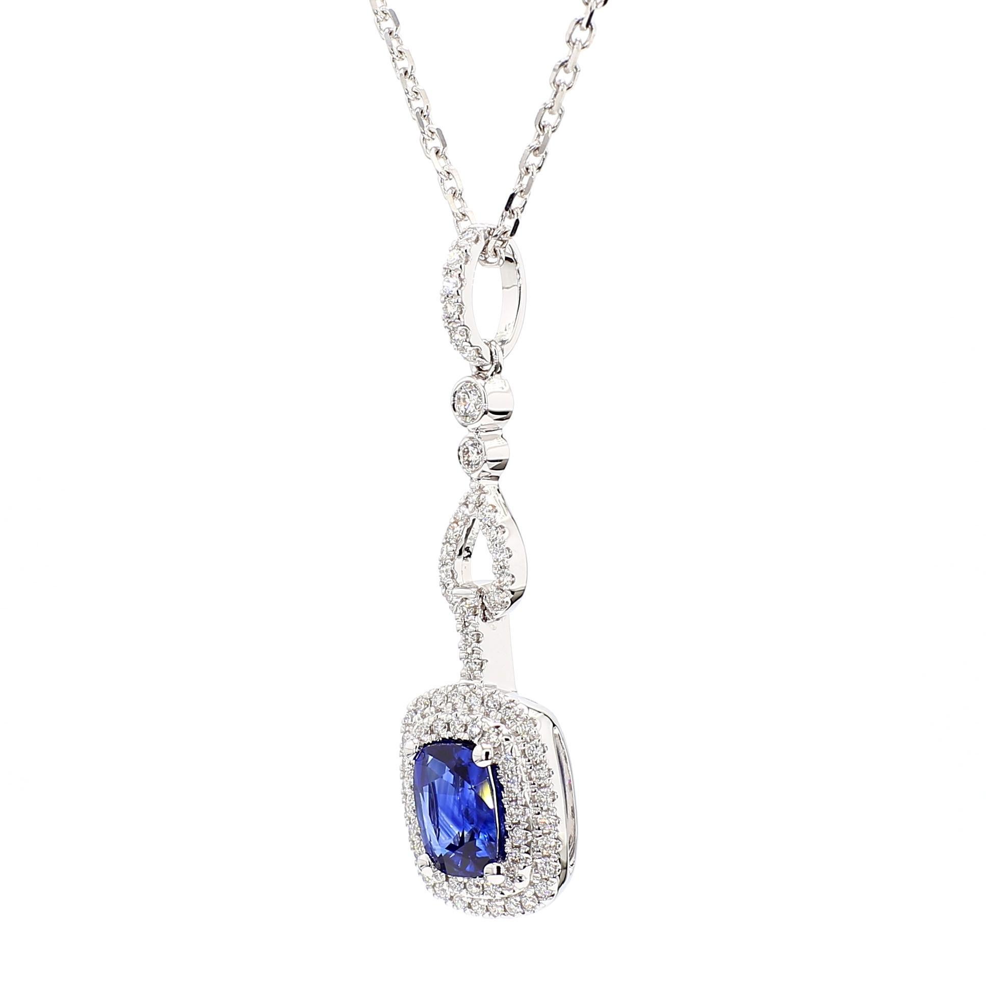 Precioso colgante de zafiro de RareGemWorld. Montada en un precioso engaste de oro blanco de 18 quilates con un zafiro azul natural talla cojín. El zafiro está rodeado de melee de diamantes blancos redondos naturales. Este colgante impresionará y