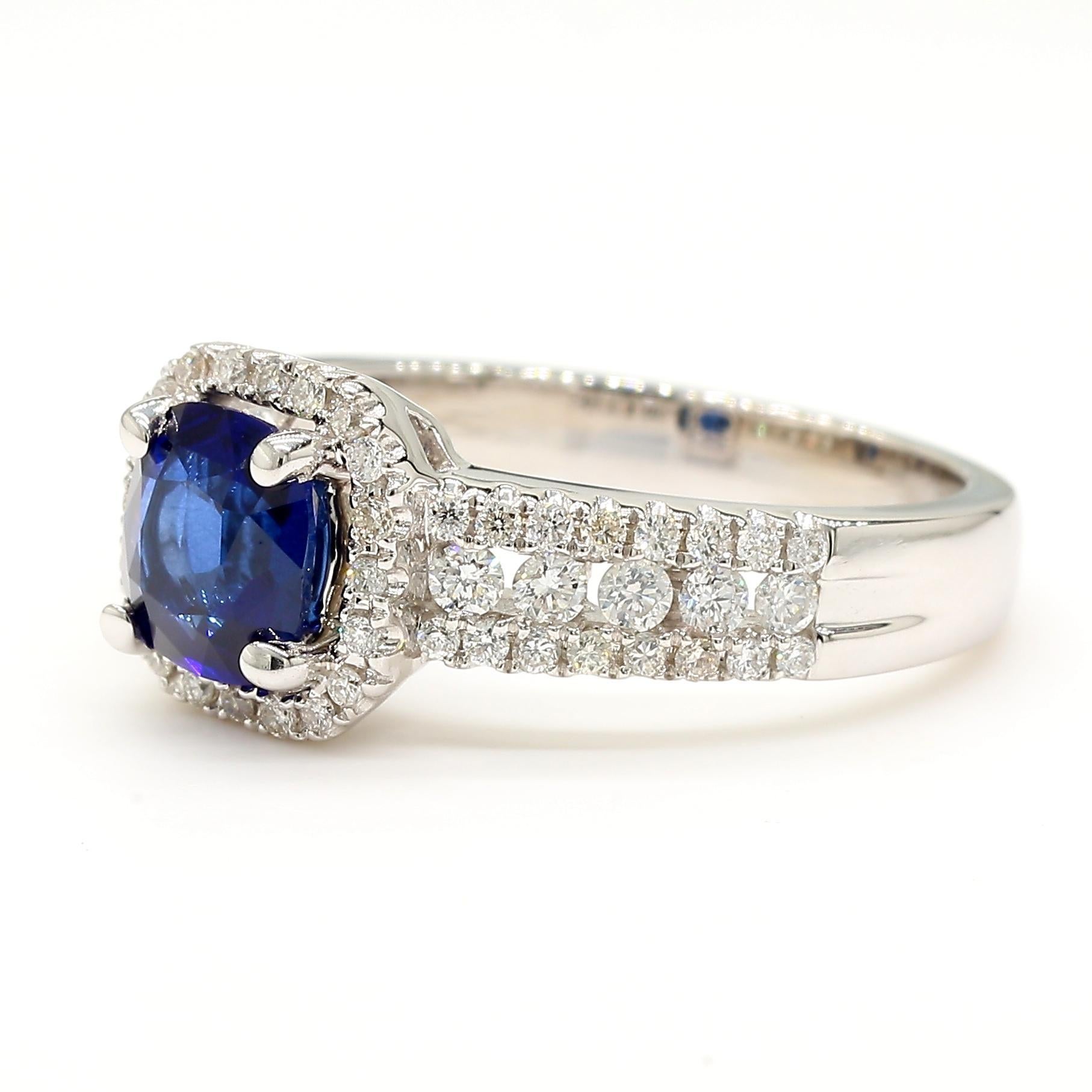 La magnifique bague en saphir de Raregemworld. Monté dans une belle monture en or blanc 14 carats avec un saphir bleu naturel de taille coussin. Le saphir est entouré d'une mêlée de diamants blancs ronds naturels. Cette bague est garantie pour