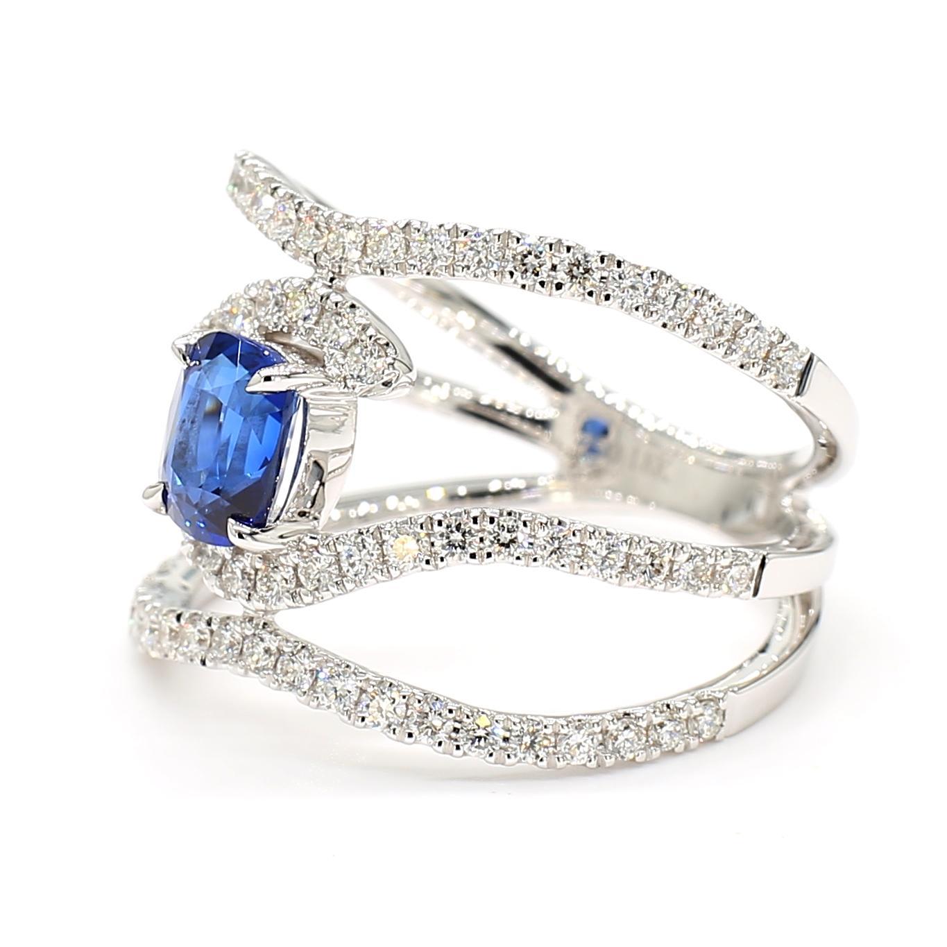 Precioso anillo de zafiro de RareGemWorld. Montada en un precioso engaste de oro blanco de 18 quilates con un zafiro azul natural talla cojín. El zafiro está rodeado de melee de diamantes blancos redondos naturales. Este anillo impresionará y