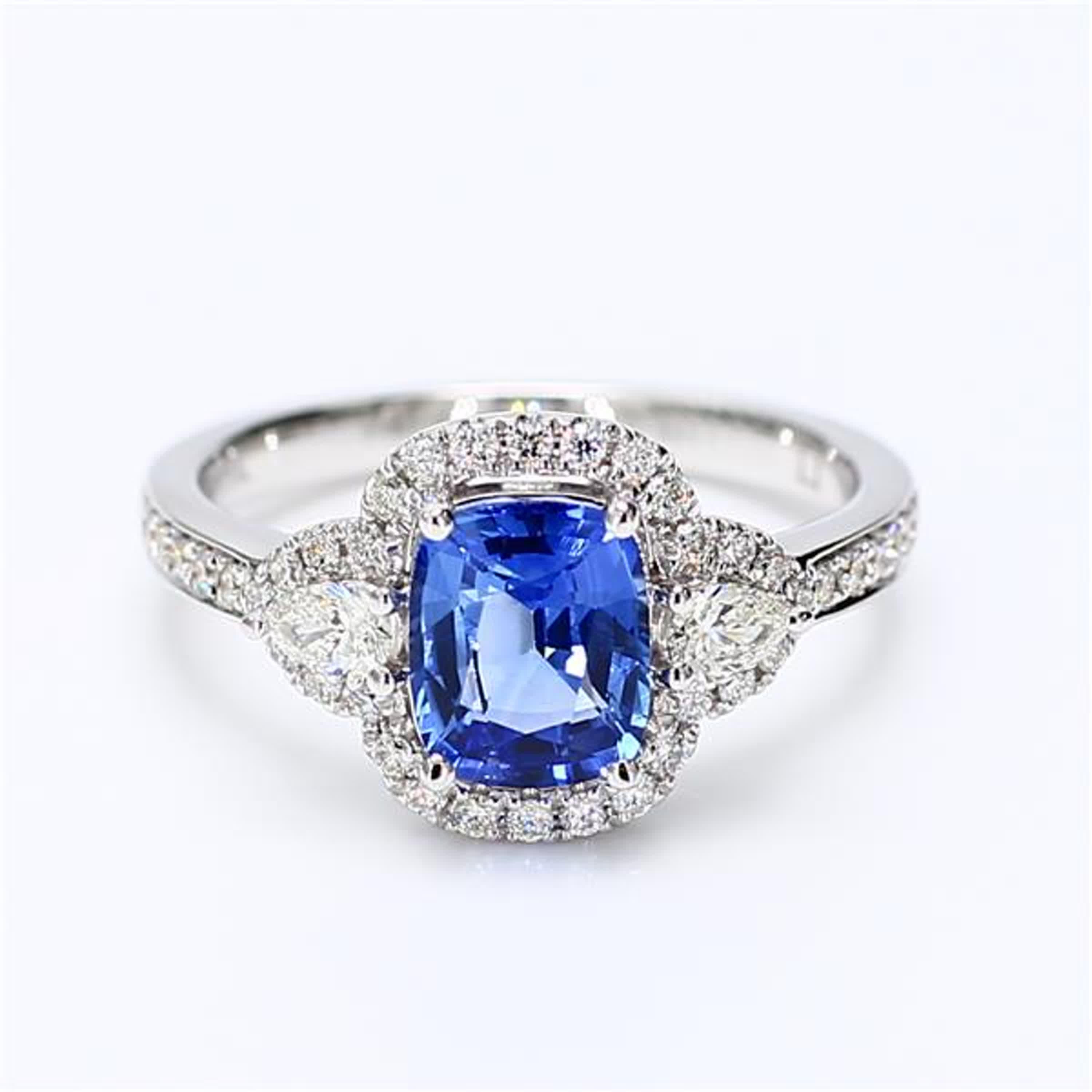 RareGemWorld's classic sapphire ring. Mounted in a beautiful 18K White Gold setting with a natural cushion cut blue sapphire. The sapphire is surrounded by natural round white diamond melee as well as natural pear cut white diamonds. This ring is