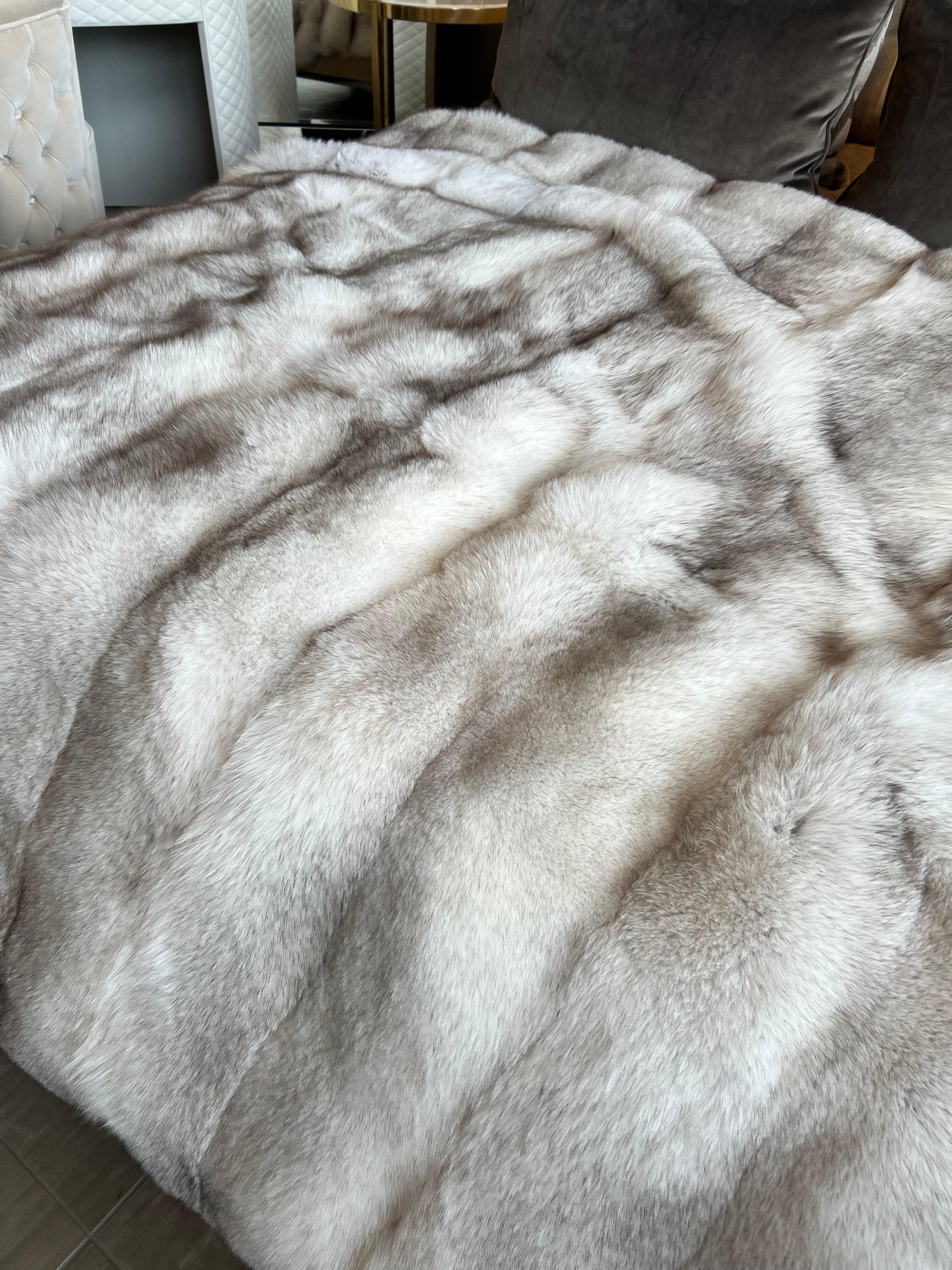 Natural blue fox Canadian dense fur throw. The name shouldn't fool you. The colour is actually white with a hint of grey tips.
This king size throw blanket has an ivory silk backing.